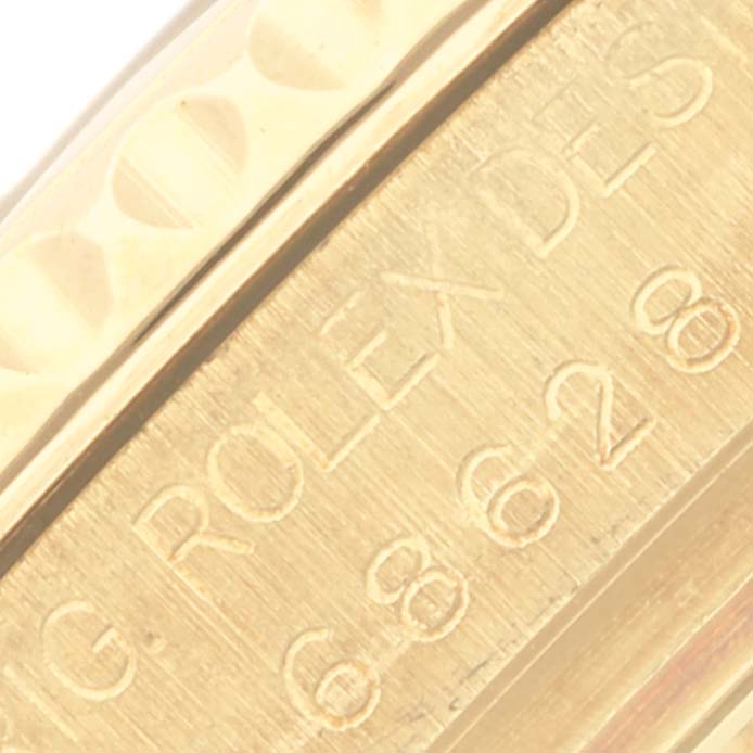 The image shows a close-up of the side engraving on a Rolex Mid-Size watch, displaying part of the bezel and the engraved text.