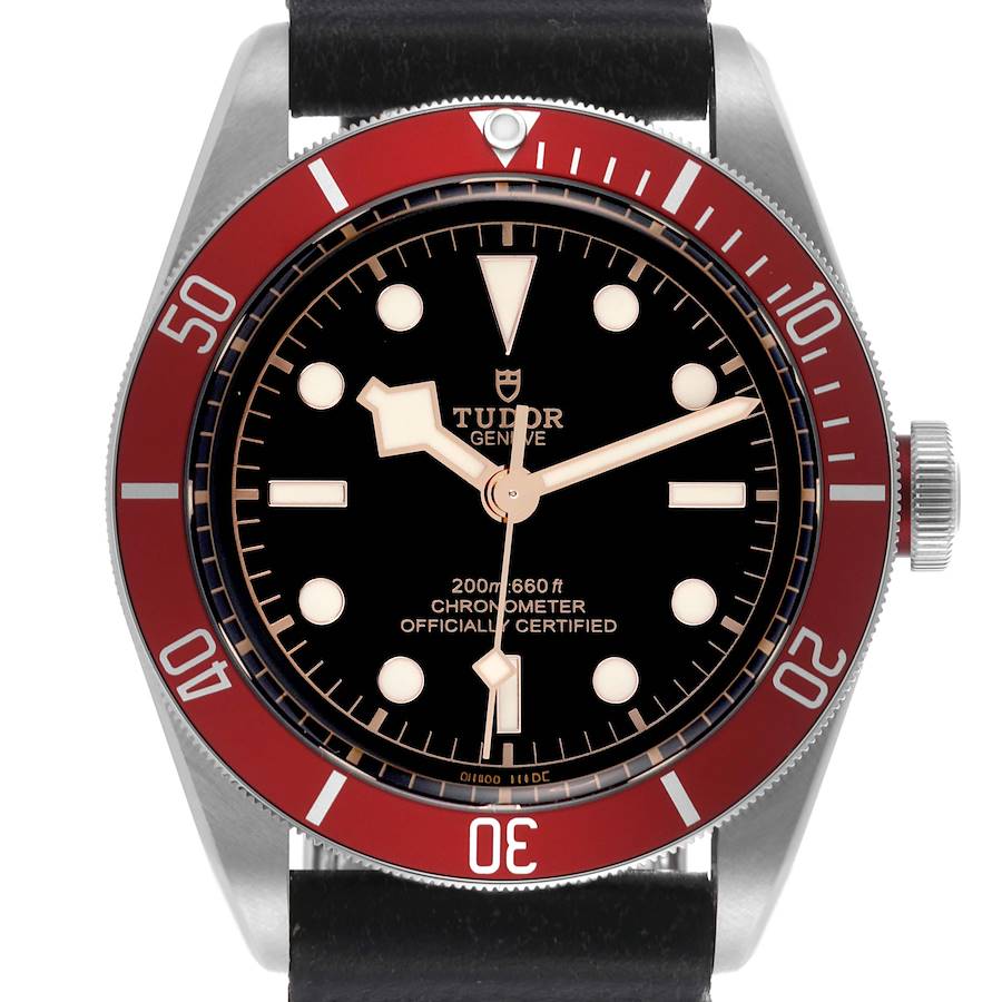 The Tudor Heritage Black Bay watch is shown from a top view, highlighting the dial, bezel, and part of the strap.