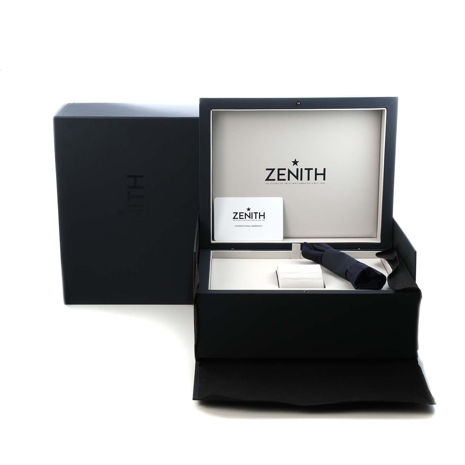The image shows the open box of a Zenith Chronomaster 03.3107.3600 Men's Stainless Steel Green Dial watch with branding, a warranty card, and a strap inside, viewed from the front.