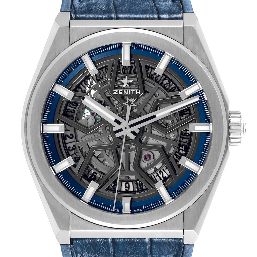 The Zenith Defy watch is shown from a front angle, highlighting its skeleton dial and blue leather strap.