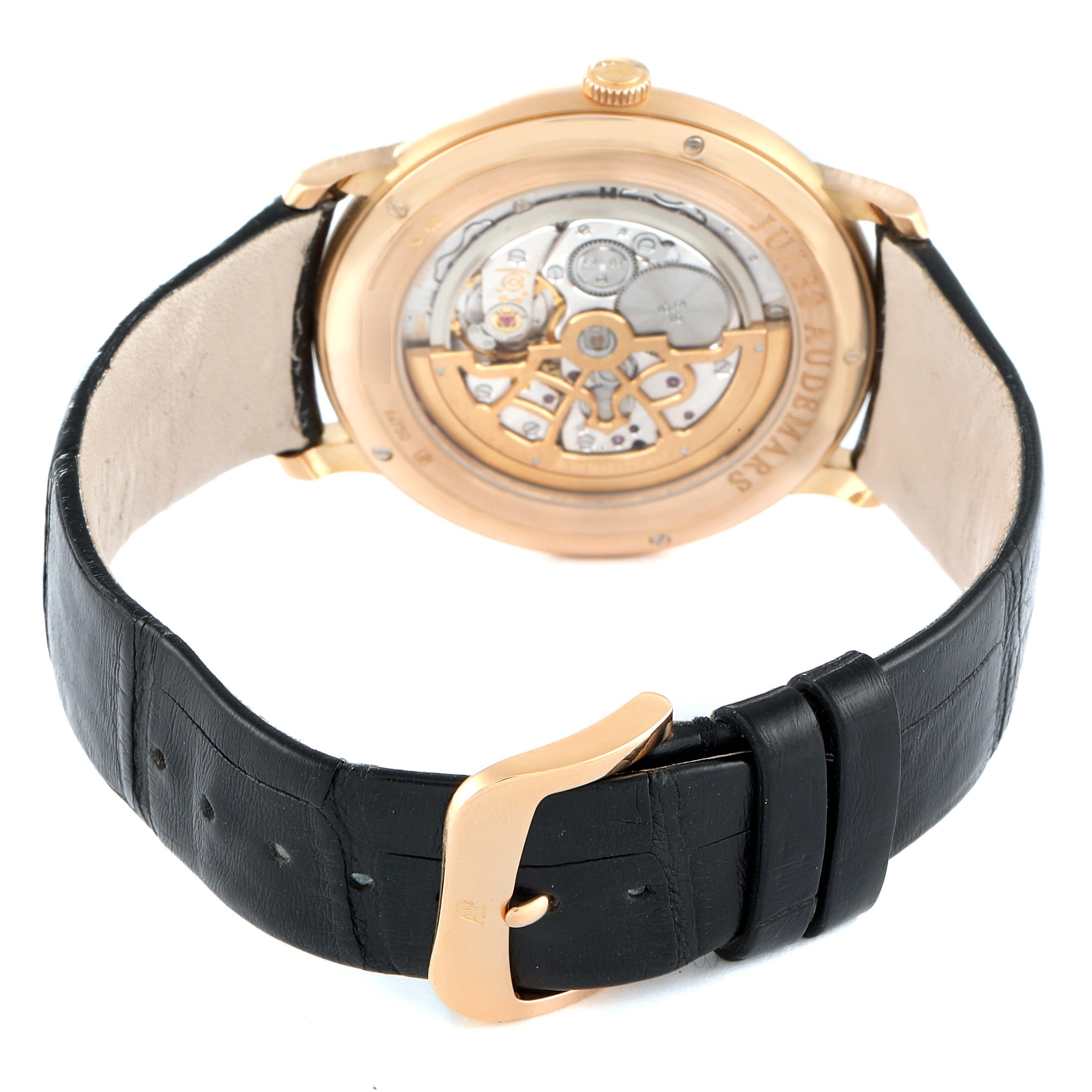 The image shows the back view of the Audemars Piguet Jules 15180OR.OO.A102CR.01 Men's Rose Gold Silver Dial 15180OR.OO.A102CR.01 Men's Rose Gold Silver Dial model watch, highlighting the movement mechanism and the leather strap with buckle.