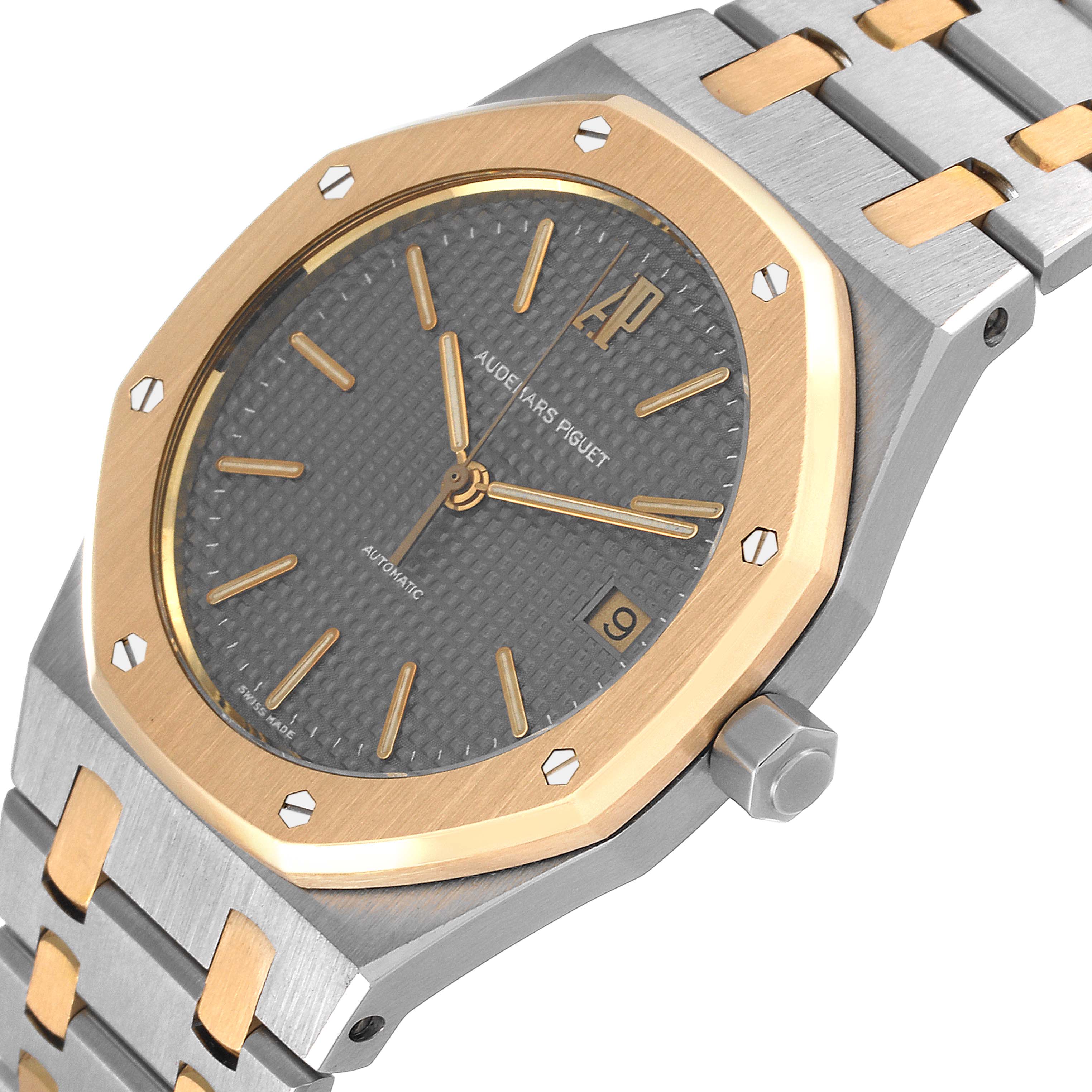 The image shows a close-up angle of an Audemars Piguet Royal Oak 14790SA.OO.0789SA.01 Men's Steel and Gold (two tone) Grey Dial 14790SA.OO.0789SA.01 Men's Steel and Gold (two tone) Grey Dial watch, featuring the watch face, bezel, crown, and part of the bracelet.