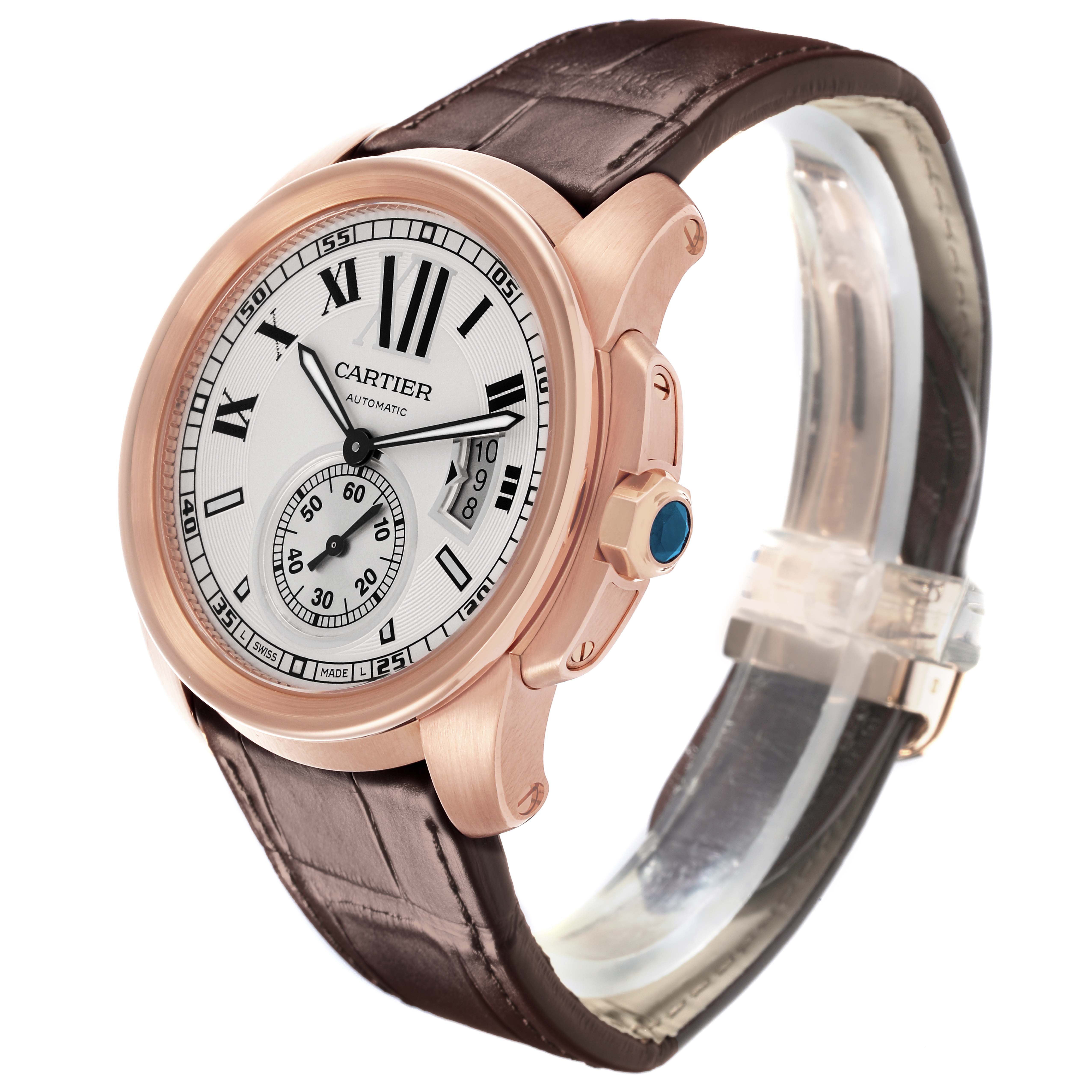 The Calibre de Cartier watch is shown at an angled side view, highlighting the dial, crown, and leather strap.