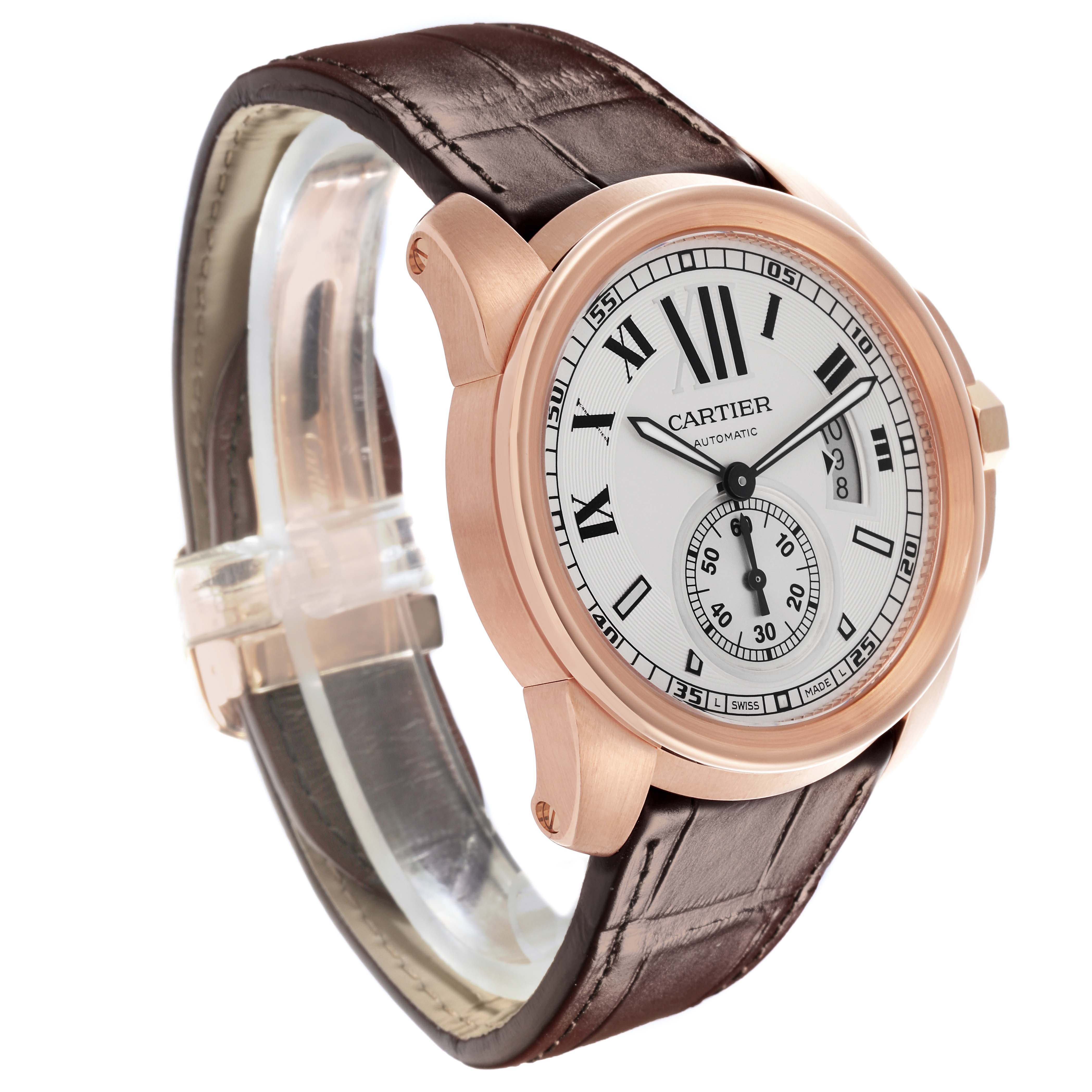 The Calibre de Cartier watch is shown at a three-quarter angle, displaying the face, bezel, and brown leather strap.