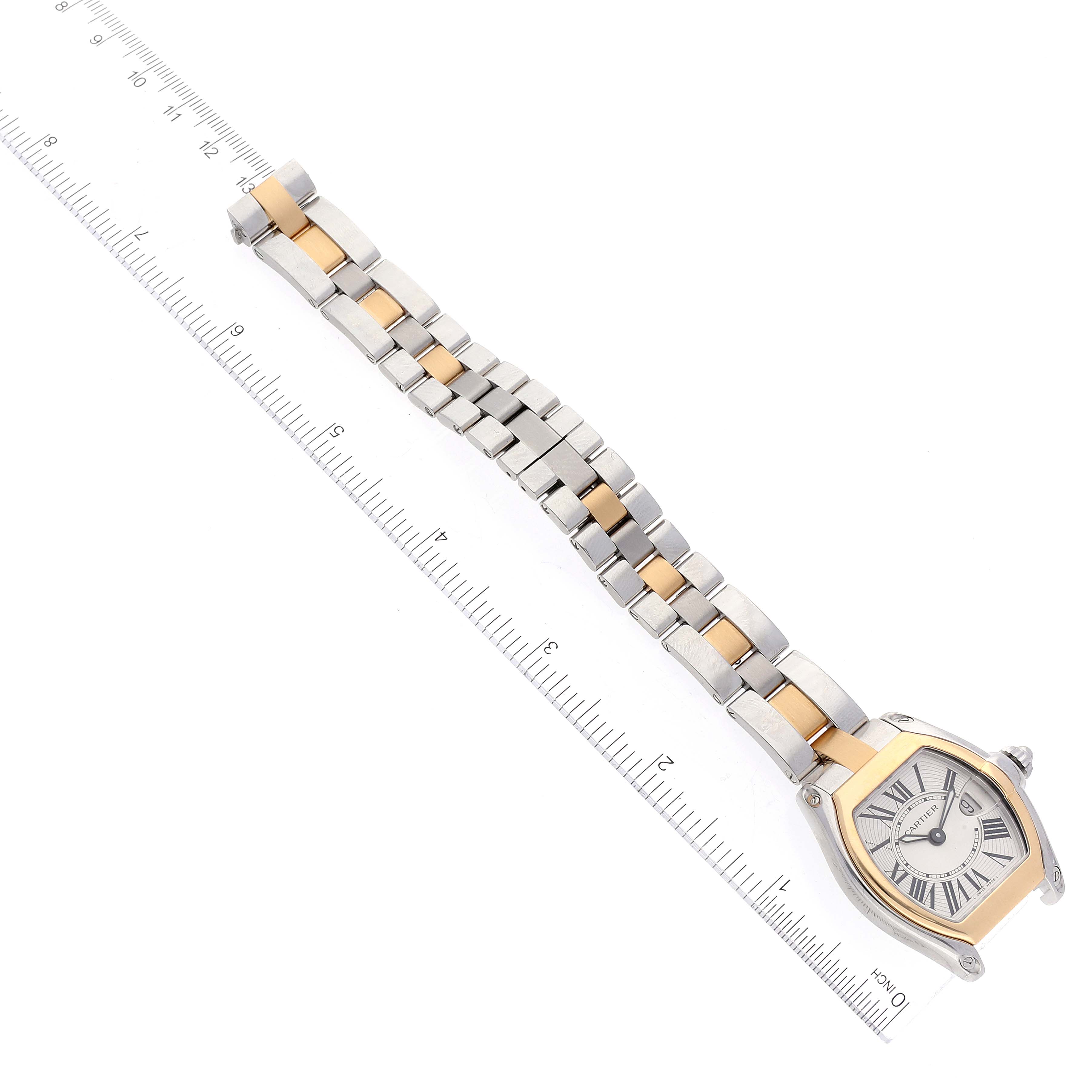 The image shows the Cartier Roadster W62026Y4 Women
s Steel and Gold (two tone) Silver Dial W62026Y4 Women
s Steel and Gold (two tone) Silver Dial watch laid flat on a ruler, displaying the entire bracelet and the watch face from a top-down angle.