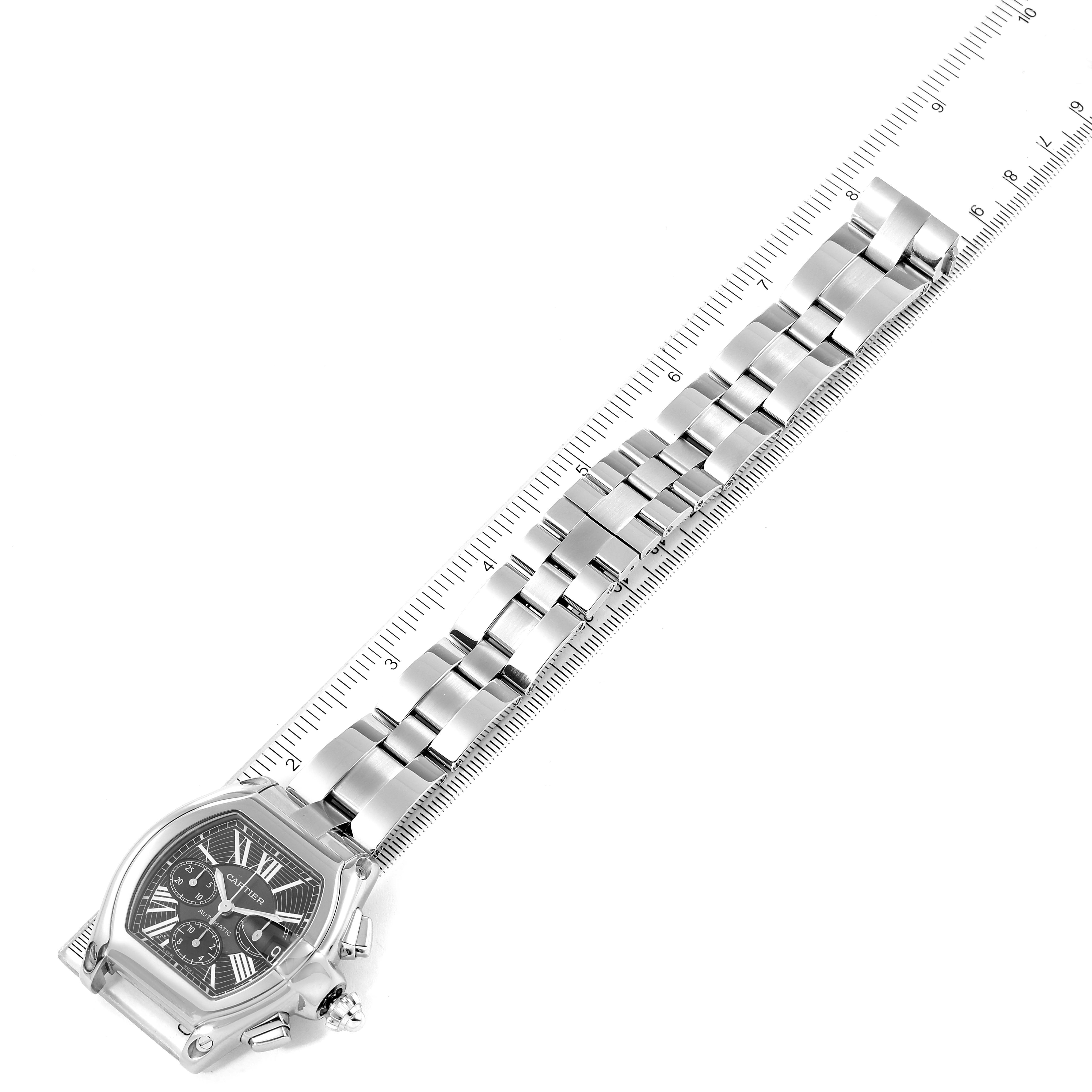 The image shows the entire face and bracelet band of the Cartier Roadster W62020X6 Men's Stainless Steel Black Dial W62020X6 Men's Stainless Steel Black Dial watch laid flat alongside a ruler.