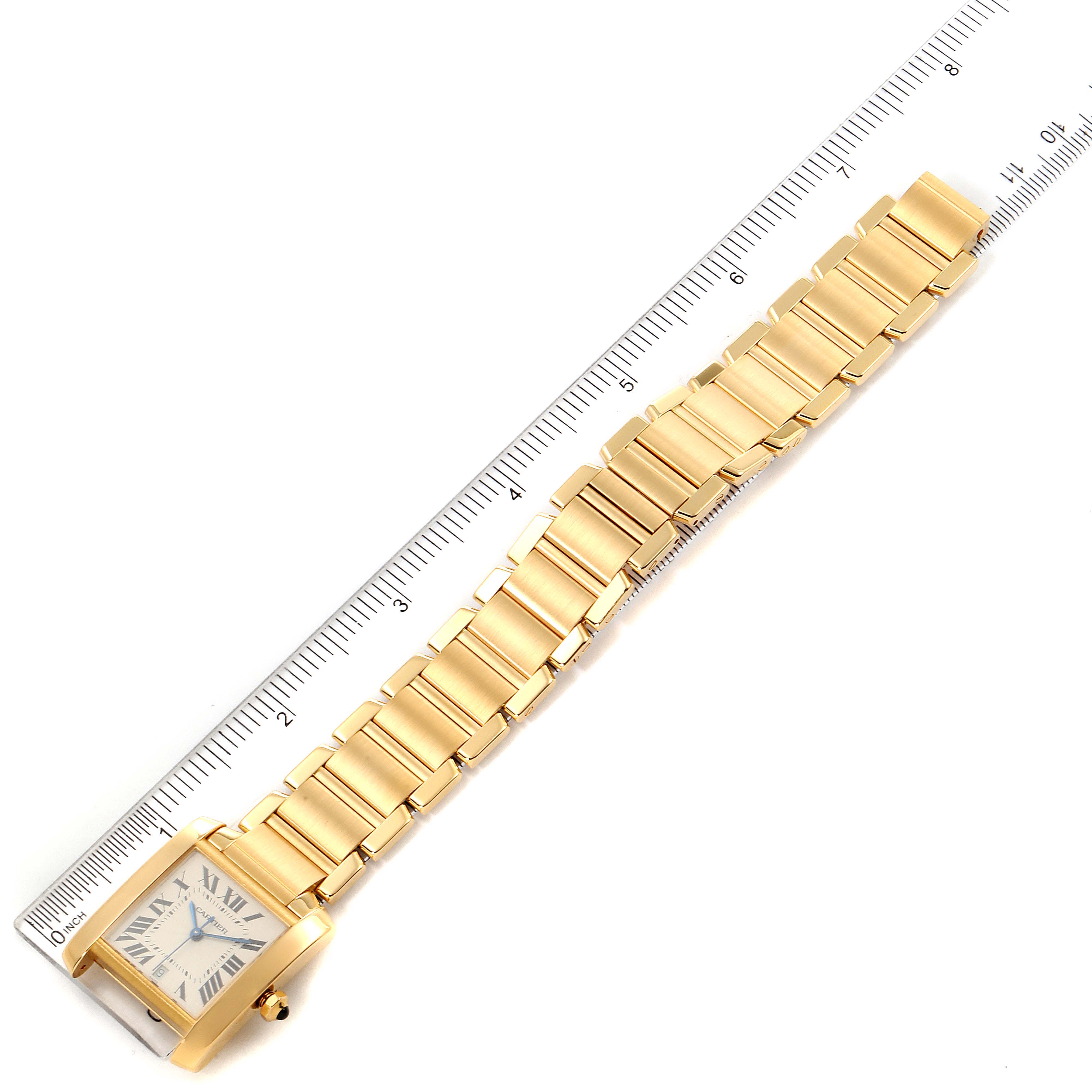 The image shows a Cartier Tank Francaise W50001R2 Men's Yellow Gold Silver Dial W50001R2 Men's Yellow Gold Silver Dial watch laying flat with a ruler beside it to display its length.
