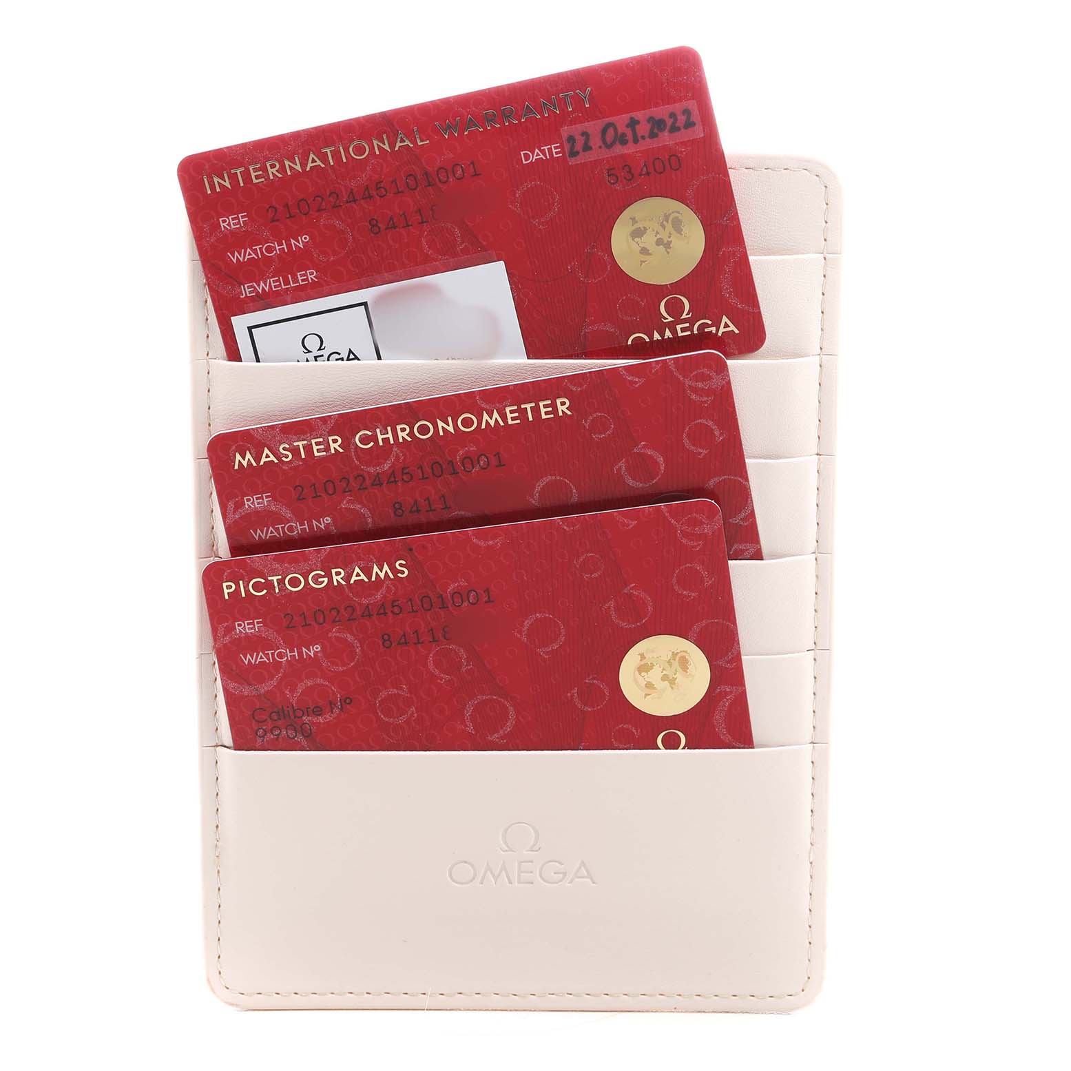 The image shows a beige Omega cardholder containing three red cards for the Seamaster model.