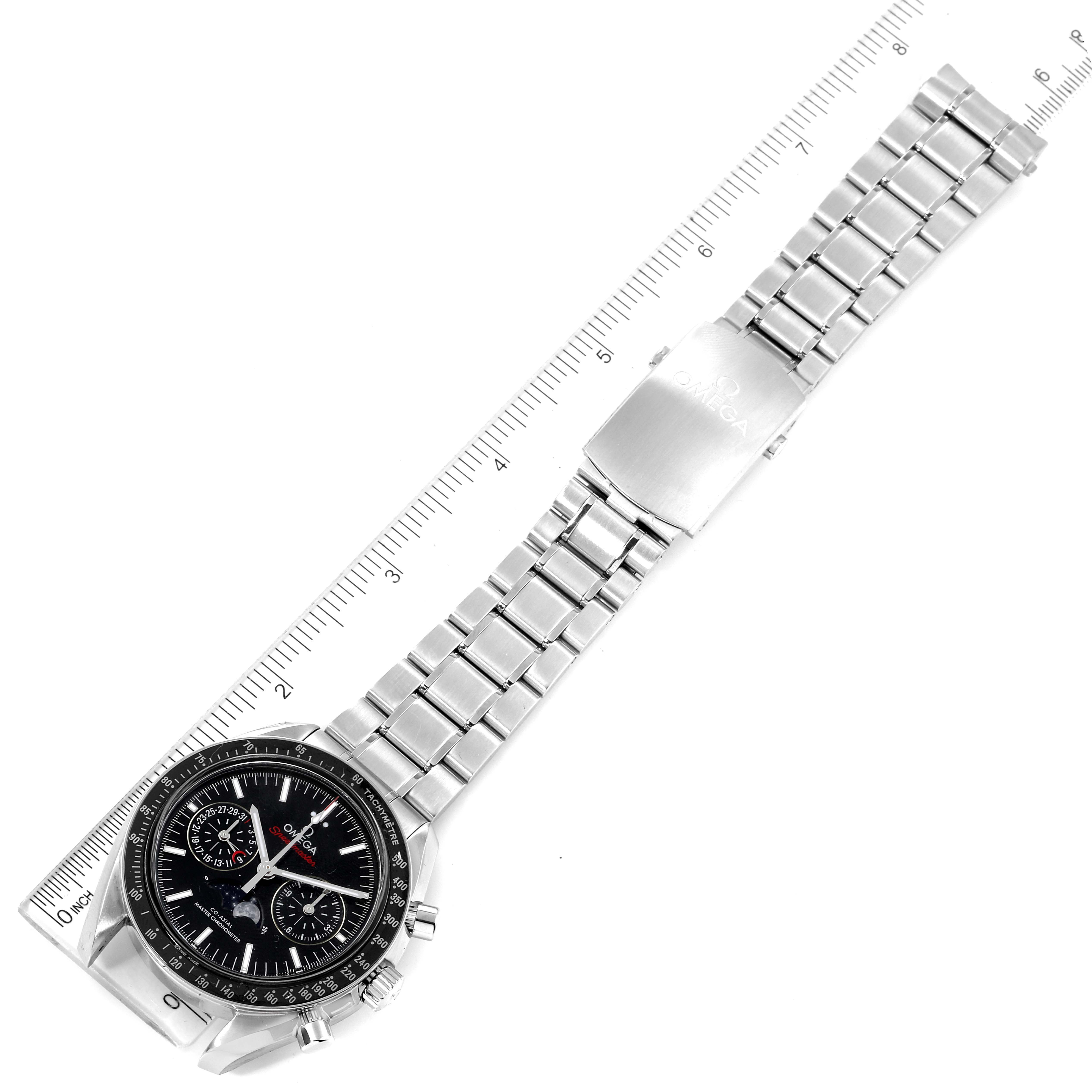 The Omega Speedmaster 304.30.44.52.01.001 Men
s Stainless Steel Black Dial 304.30.44.52.01.001 Men
s Stainless Steel Black Dial watch is shown at an overhead angle, displaying the bracelet, clasp, and face alongside a ruler for scale.