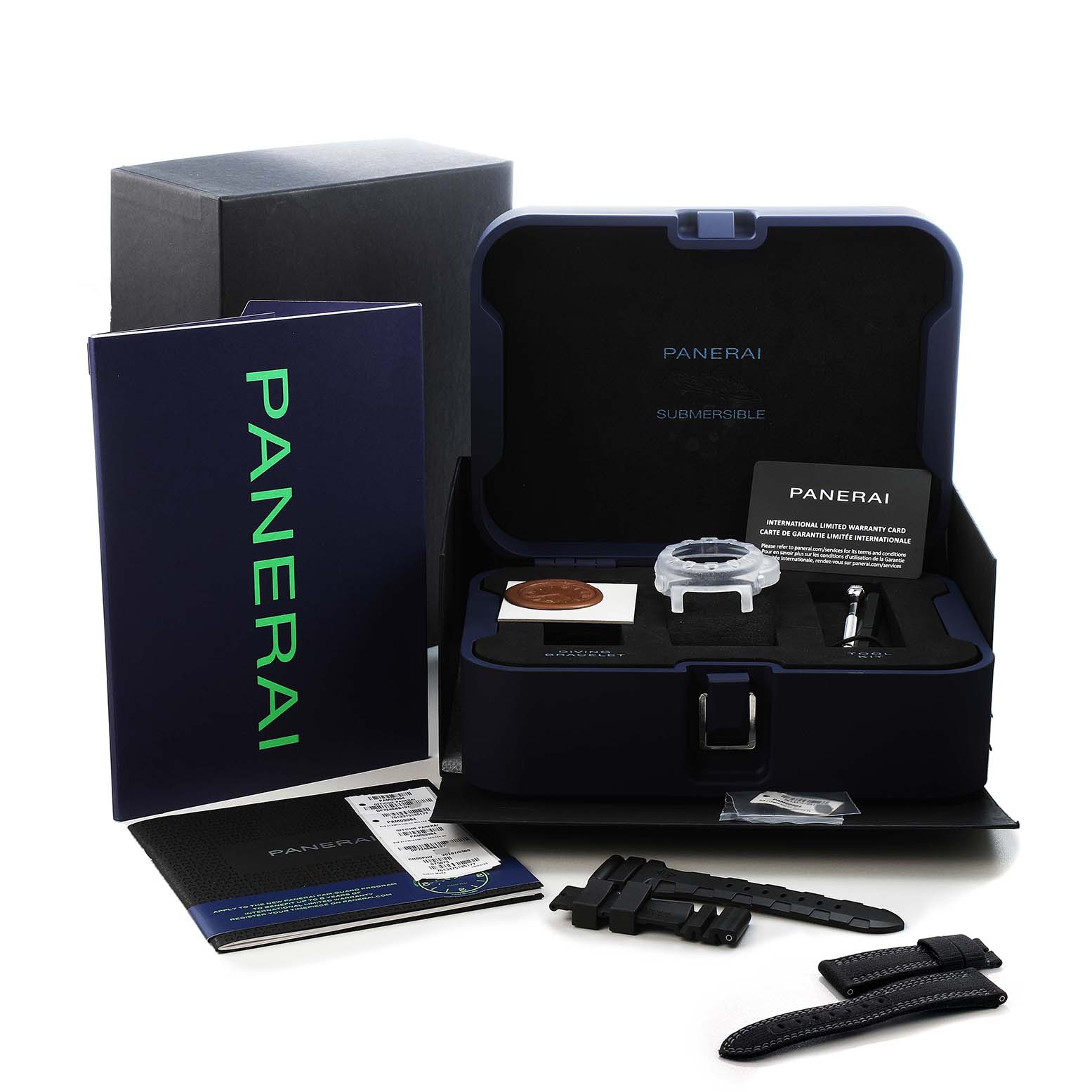 The image shows a Panerai Submersible PAM00984 Men's Titanium Black Dial model in its open box with documents, additional straps, a tool, and a watch case protector.