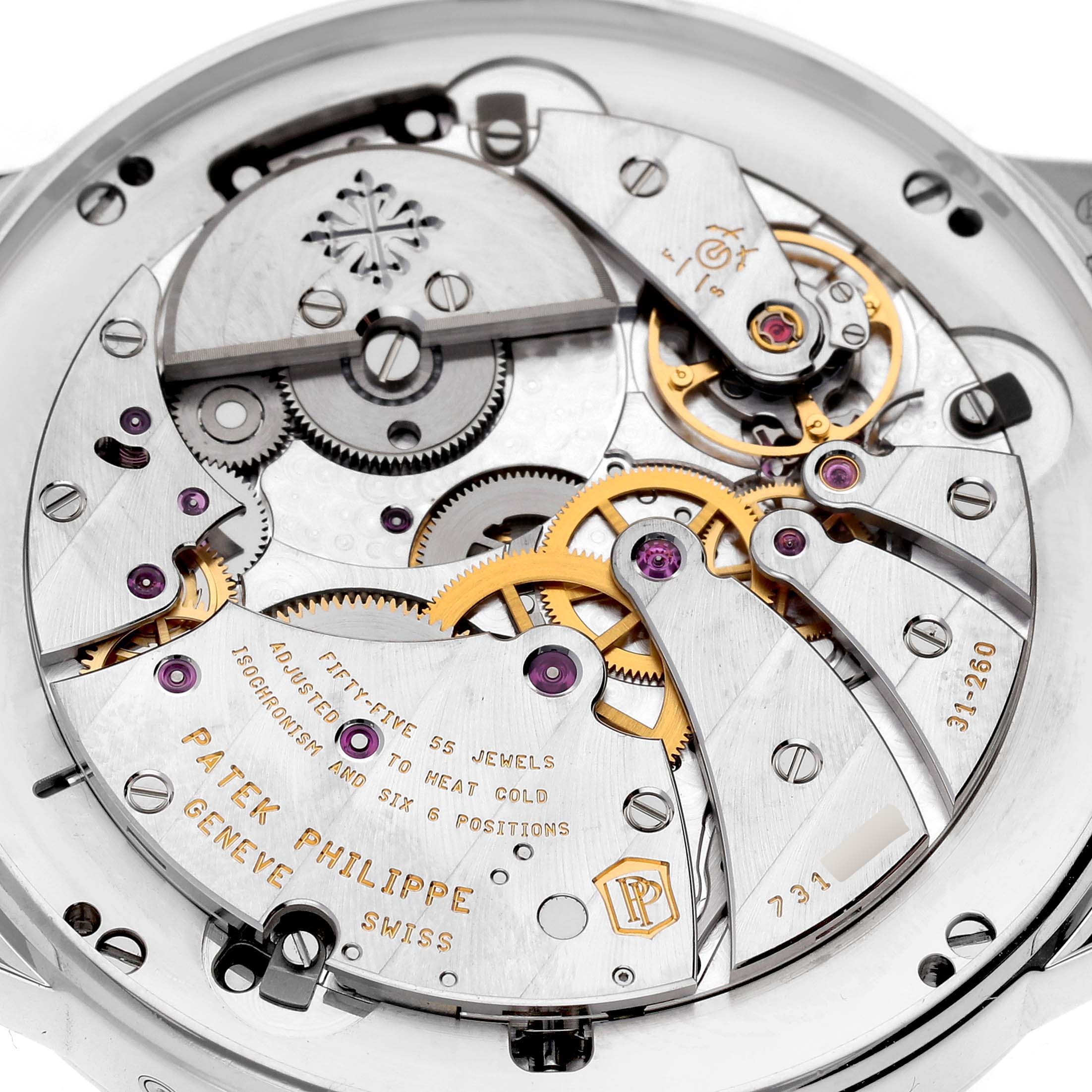 The image shows a close-up of the movement of a Patek Philippe Complications 5236 Men's Platinum Blue Dial watch, highlighting gears and intricate mechanisms.