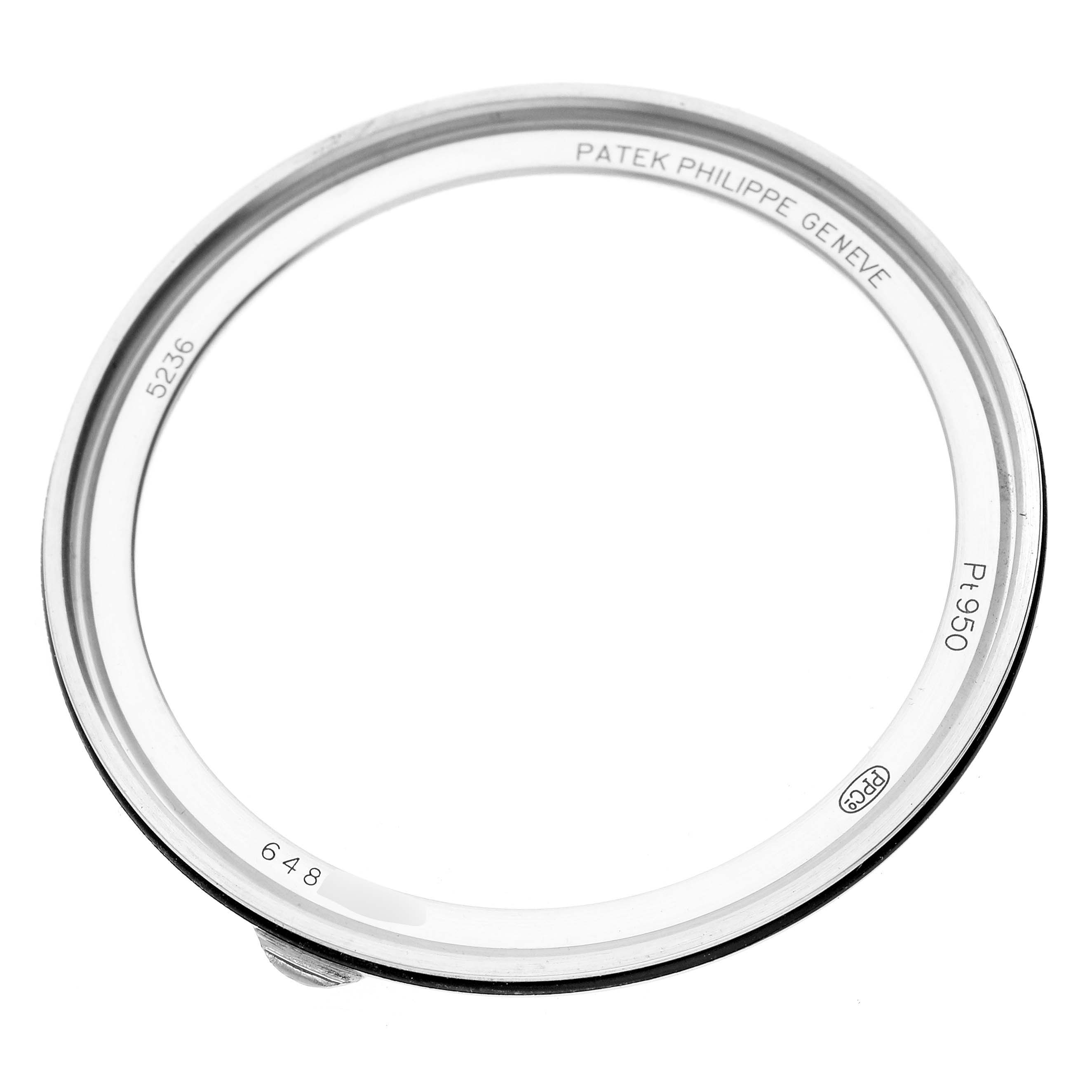 The image shows a bezel from a Patek Philippe Complications 5236 Men's Platinum Blue Dial watch, viewed from an angled perspective, highlighting engravings.