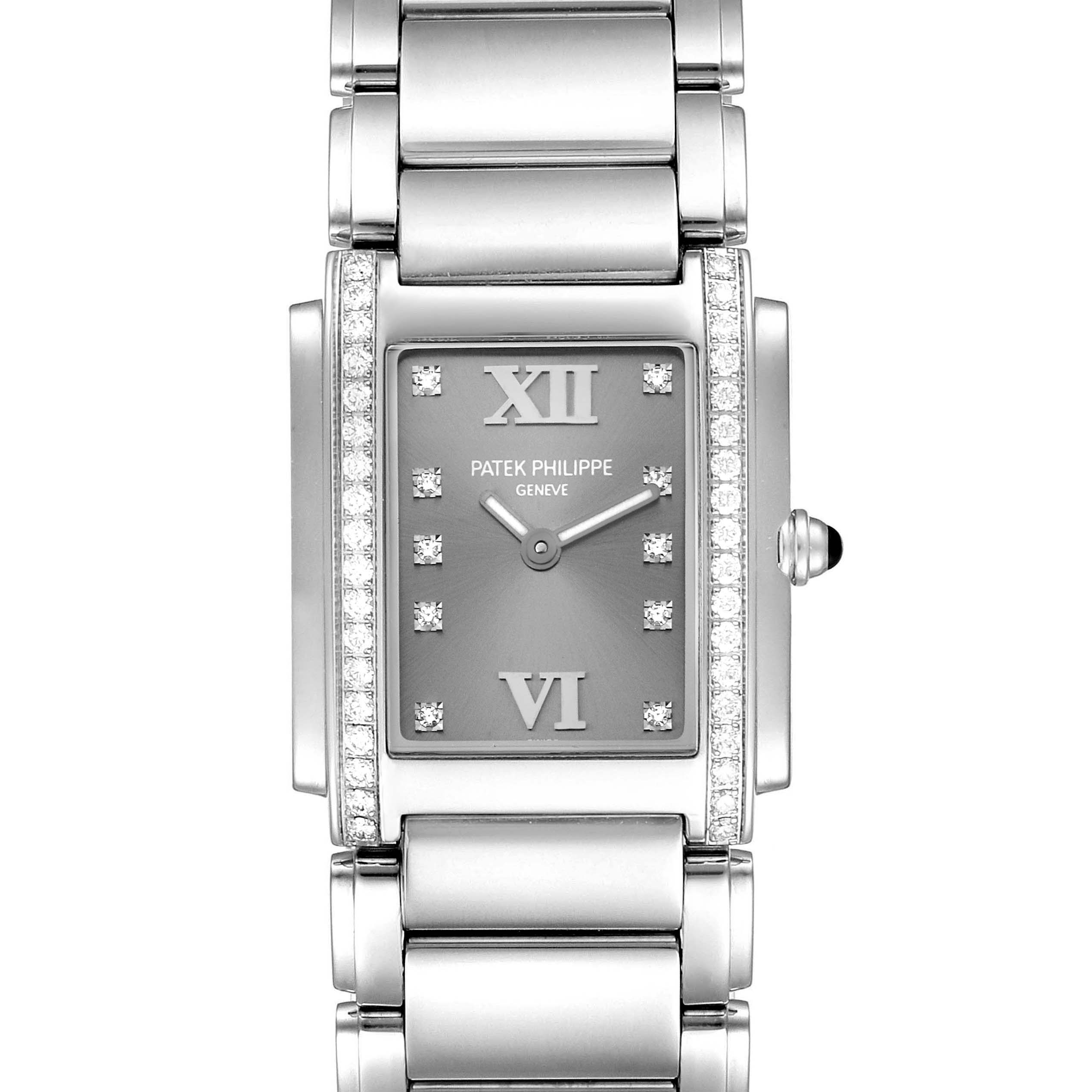 The image shows a front view of the Patek Philippe Twenty-4 4910/10A-010 Women's Stainless Steel Grey Dial 4910/10A-010 Women's Stainless Steel Grey Dial watch, highlighting its rectangular face and metallic bracelet.
