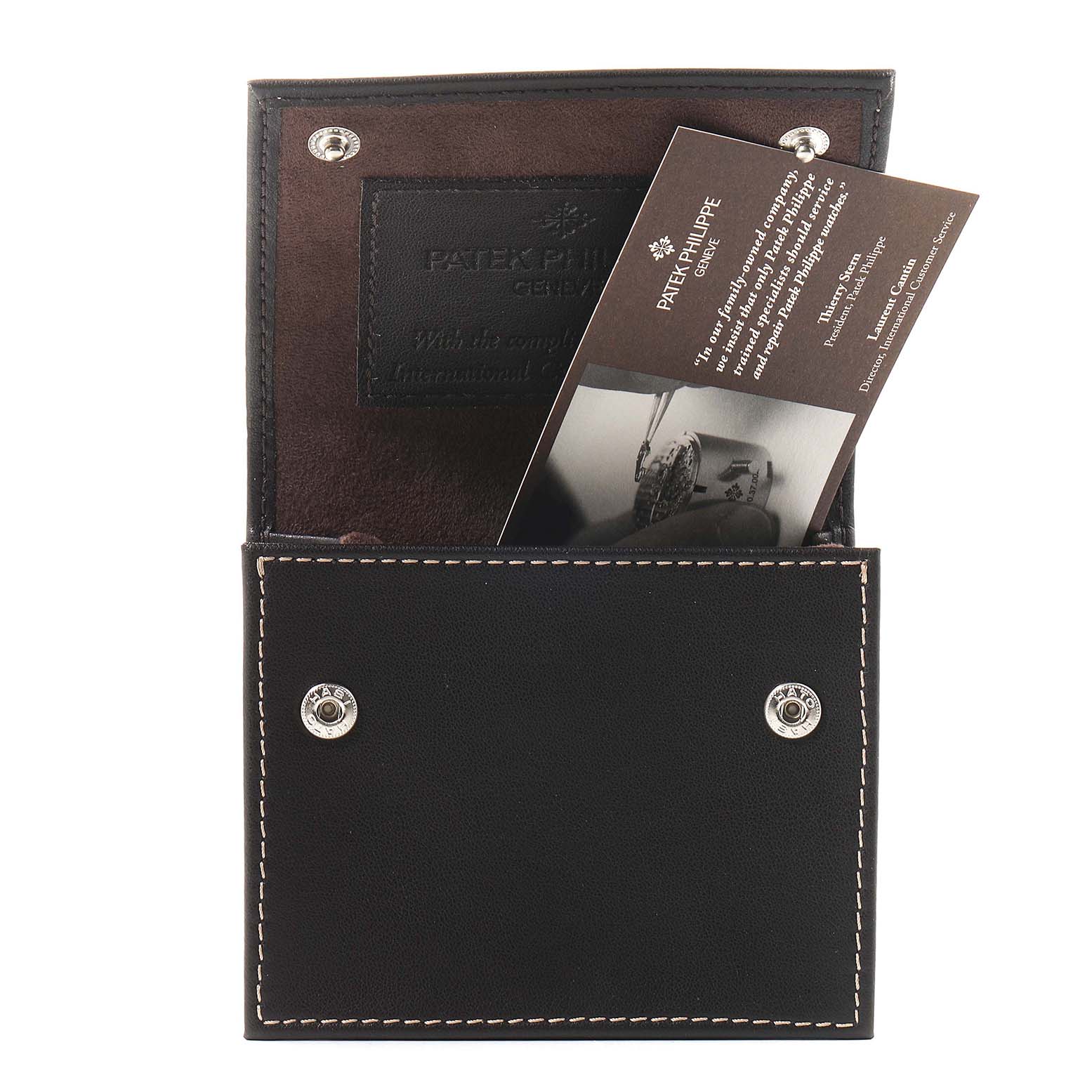 The image shows a black leather Patek Philippe pouch partially open, revealing documentation for the Twenty-4 model.