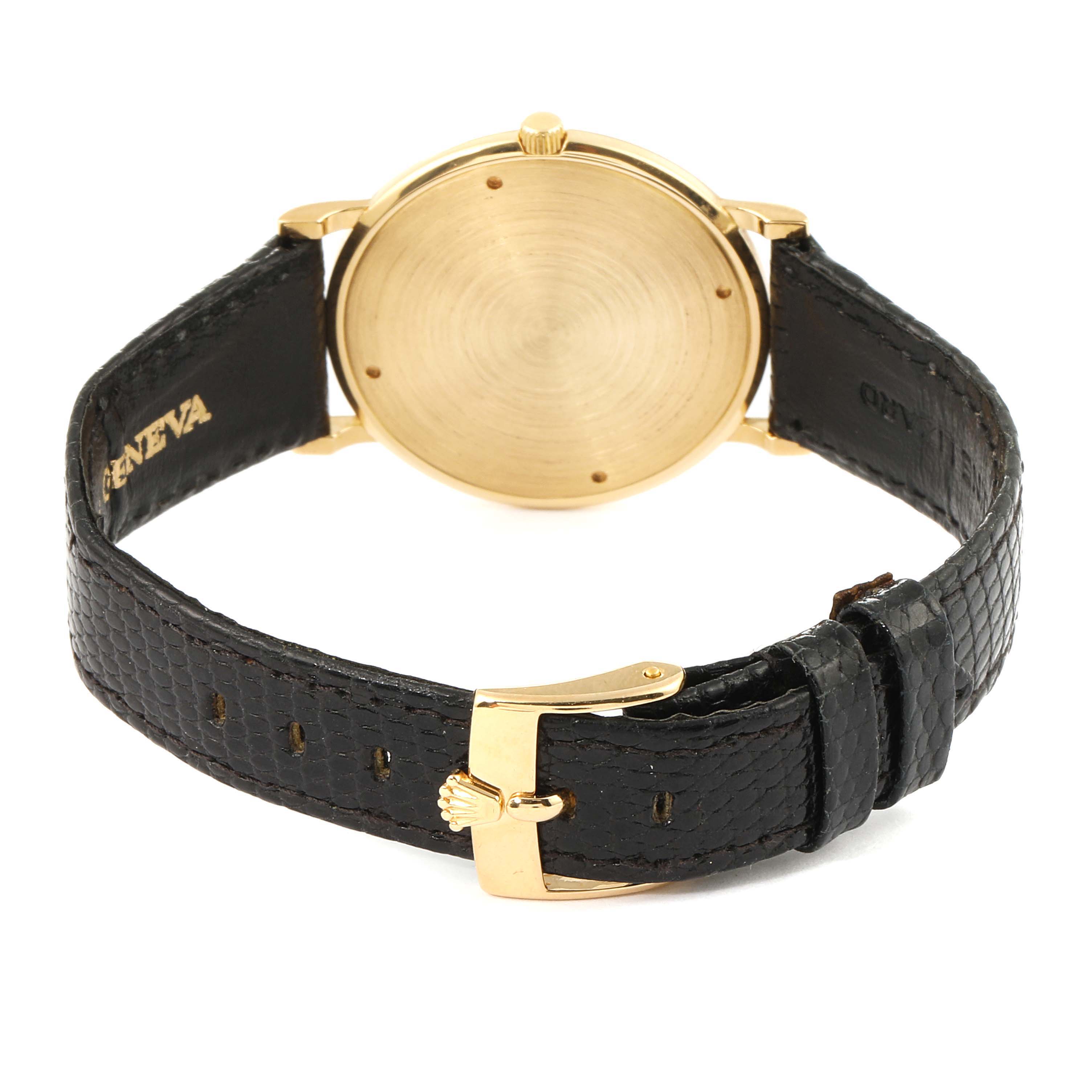 The Rolex Cellini 9576 Men's Yellow Gold Silver Dial 9576 Men's Yellow Gold Silver Dial watch is shown from the rear, displaying its gold case, crown, and black leather strap with a gold buckle.