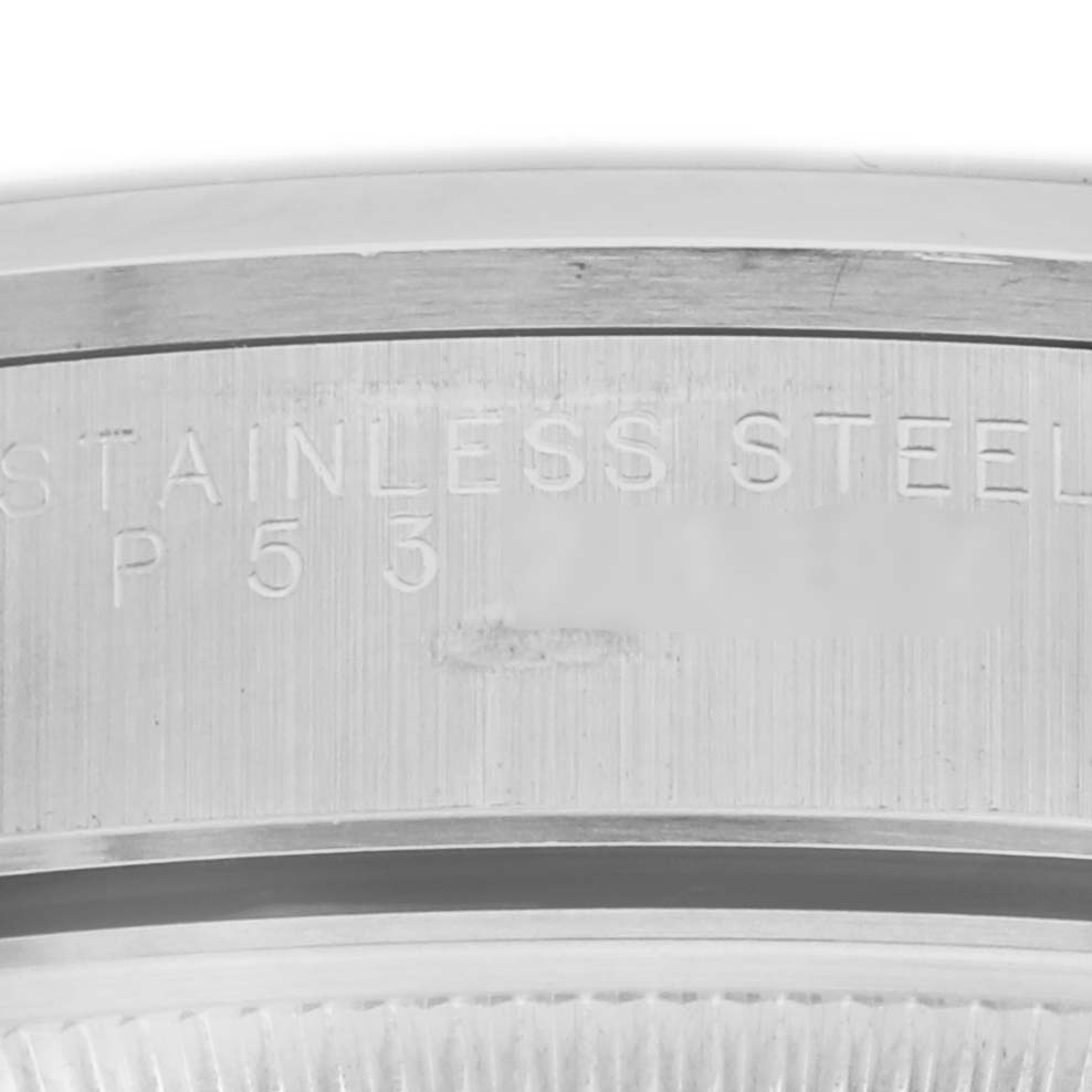 The image shows a close-up of the edge of a Rolex Date 15200 Men's Stainless Steel Black Dial 15200 Men's Stainless Steel Black Dial model, highlighting the stainless steel engraving on the case back.