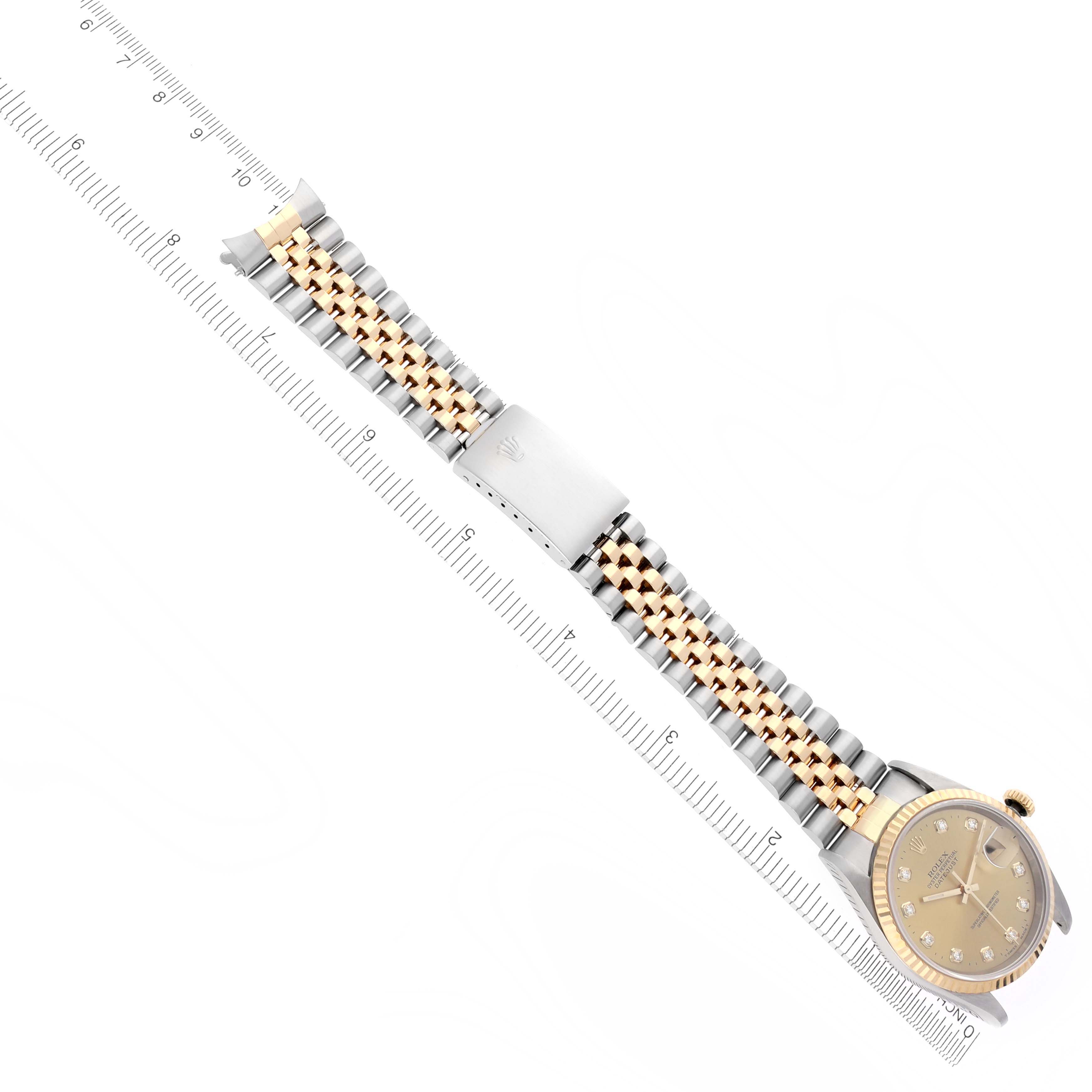 The Rolex Datejust 16233 Men's Steel and Gold (two tone) Champagne Dial 16233 Men's Steel and Gold (two tone) Champagne Dial watch is shown at a diagonal angle, displaying the gold and silver bracelet, clasp, and face with a ruler beside it.