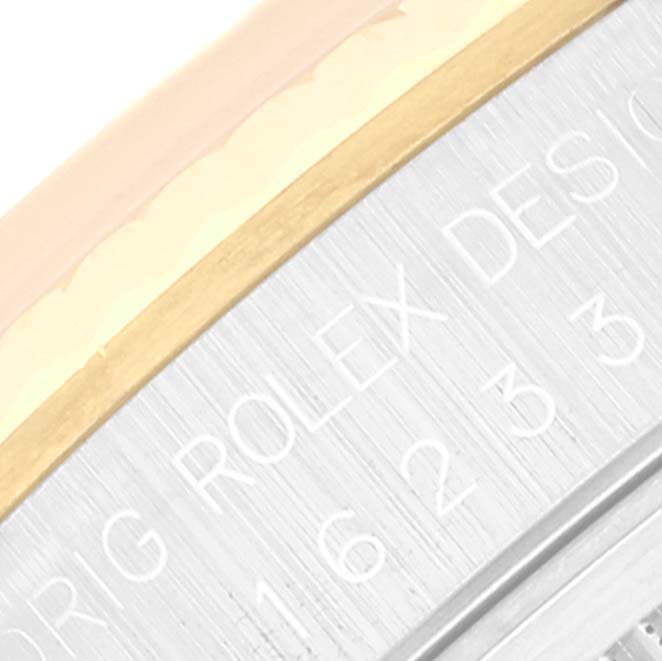 This close-up image shows the edge of the Rolex Datejust 16233 Men's Steel and Gold (two tone) Grey Dial 16233 Men's Steel and Gold (two tone) Grey Dial model, specifically highlighting parts of the case and engraved markings.