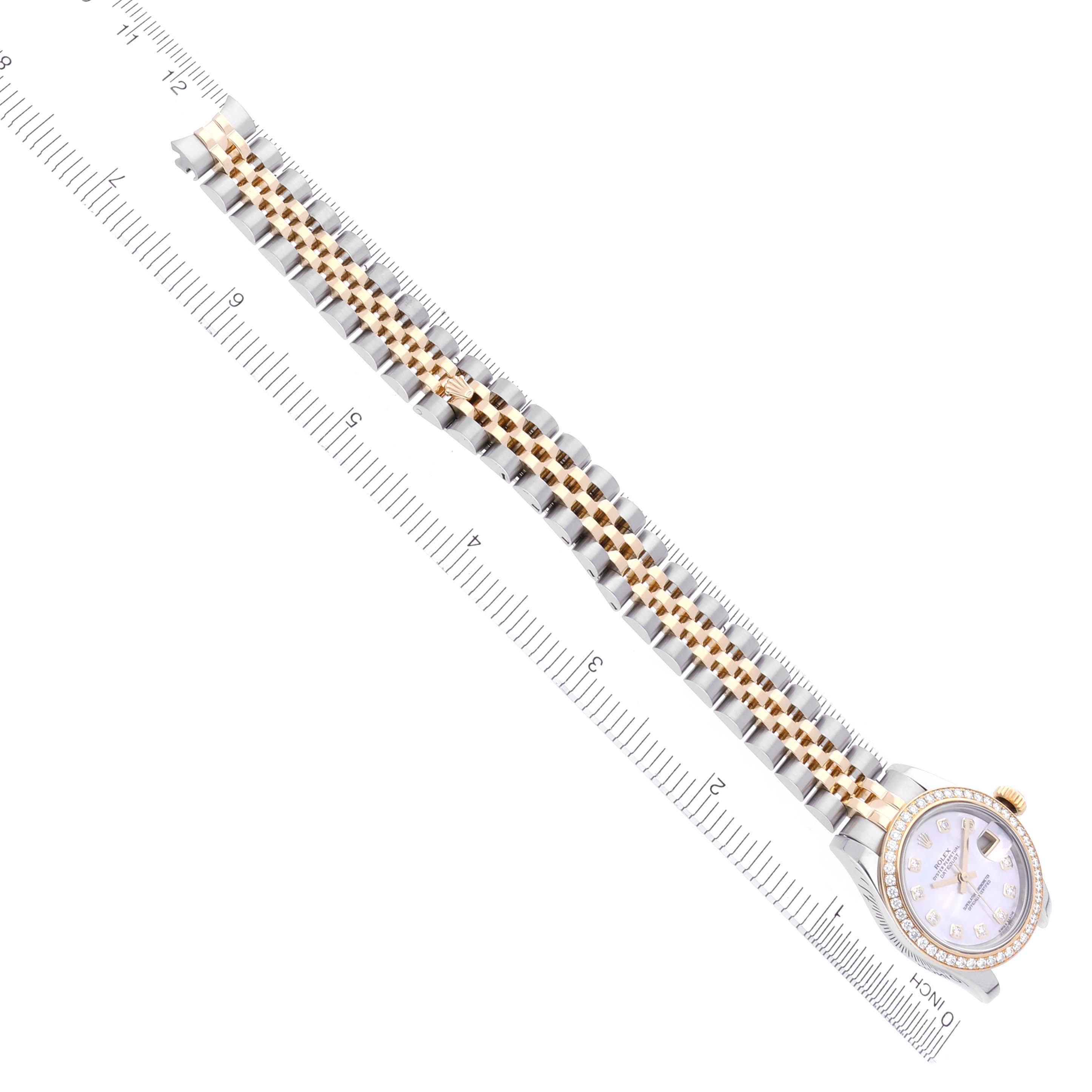 The Rolex Datejust 179383 Women's Steel and Gold (two tone) Mother of Pearl Dial 179383 Women's Steel and Gold (two tone) Mother of Pearl Dial watch is shown at an angle, highlighting its face and bracelet alongside a ruler for scale.
