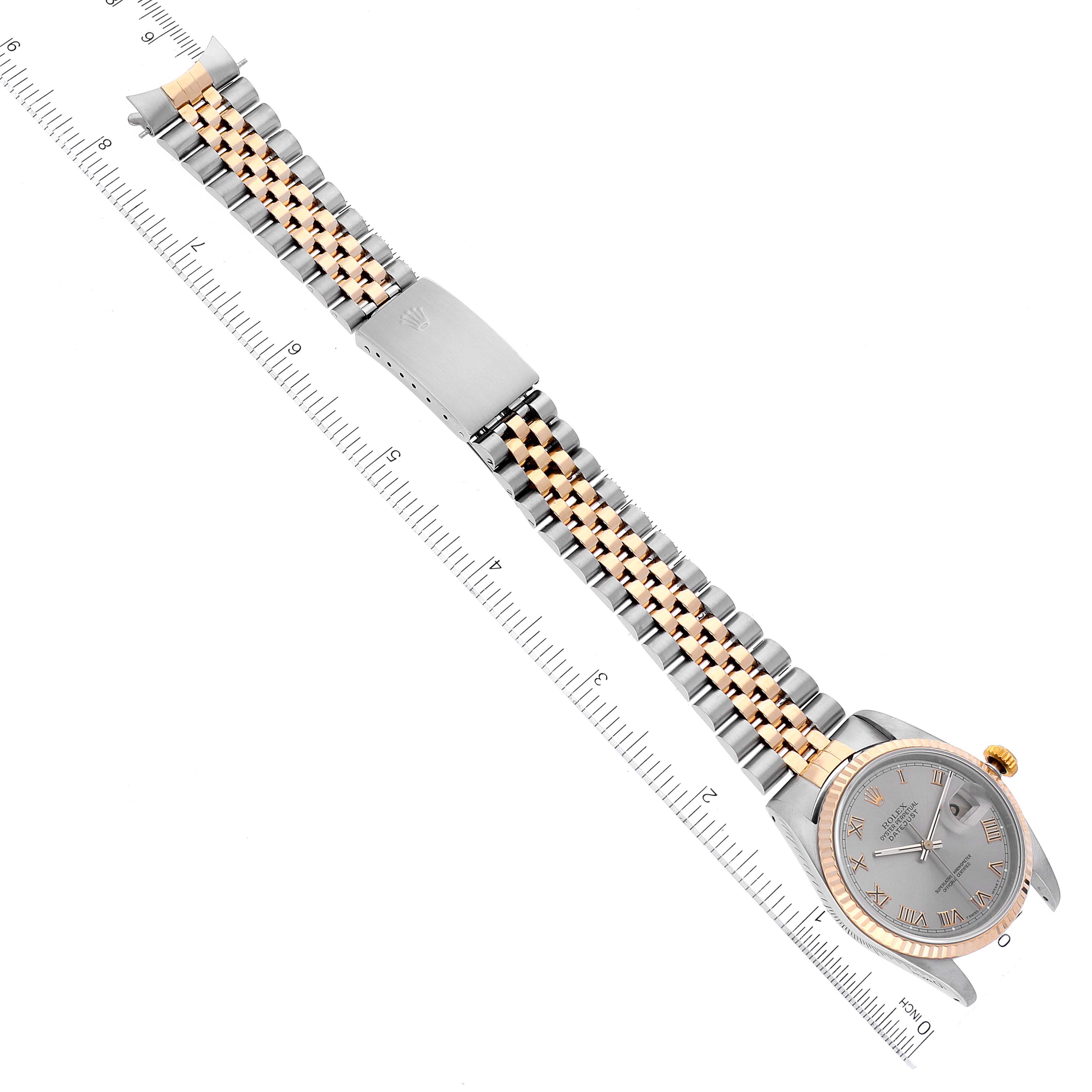 The Rolex Datejust 16233 Men's Steel and Gold (two tone) Grey Dial 16233 Men's Steel and Gold (two tone) Grey Dial watch is shown from a top-down angle, displaying the face, bezel, and entire bracelet alongside a ruler.