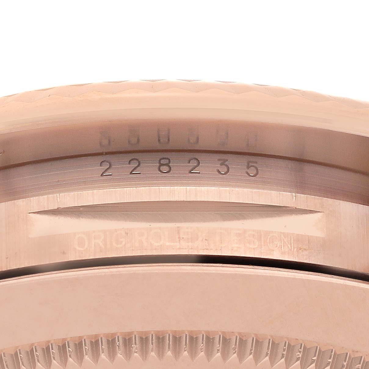 The image shows a close-up of the serial and model numbers on the case of a Rolex President 228235 Men's Rose Gold Brown Dial watch.