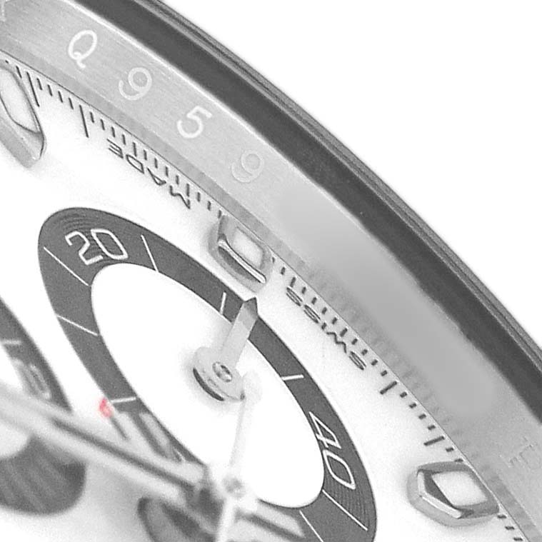 The image shows a close-up of a Rolex Daytona 116500 Men's Stainless Steel White Dial watch face, focusing on the bezel, sub-dial, and part of the hand.