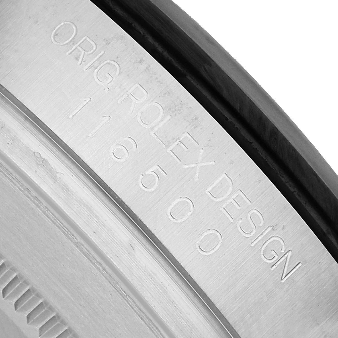 The image shows a close-up of the case edge, with engraved text "ORIG. ROLEX DESIGN 116500" on the Rolex Daytona 116500 Men's Stainless Steel White Dial.