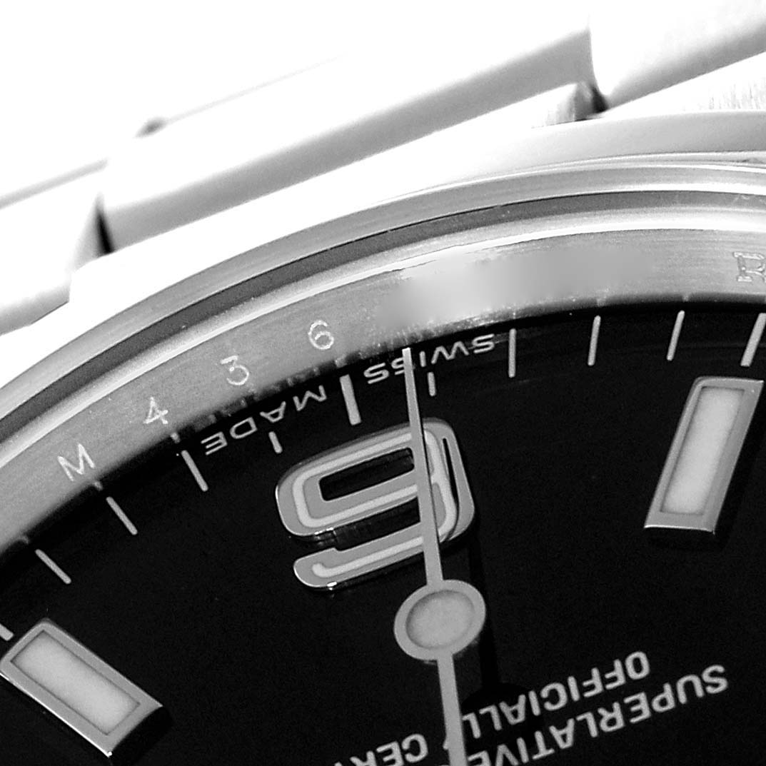 This close-up image of the Rolex Explorer 114270 Men
s Stainless Steel Black Dial 114270 Men
s Stainless Steel Black Dial watch shows a partial view of the dial, focusing on the 9 o
clock marker and some additional markers.