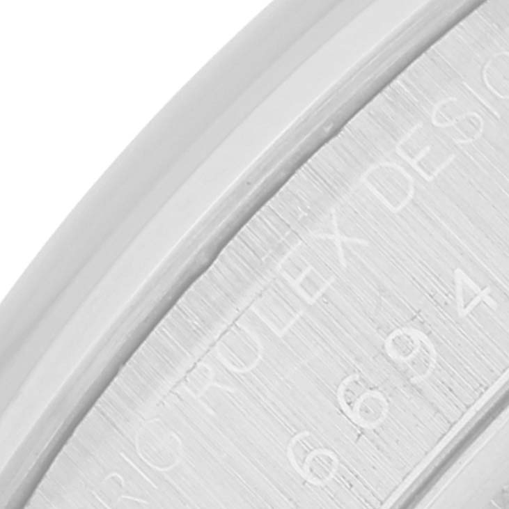 This image shows a close-up of the engraved inner bezel of a Rolex Date 6694 Men's Stainless Steel Black Dial 6694 Men's Stainless Steel Black Dial model watch, displaying part of "ROLEX DESIGN" and numerals.