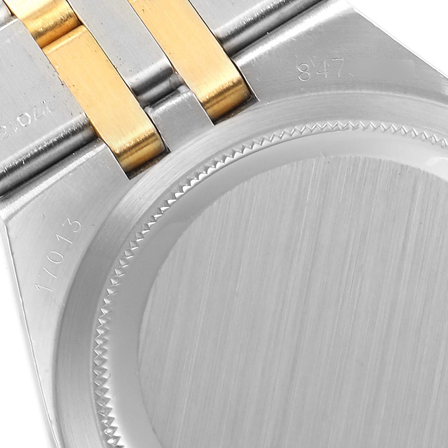 The image shows the back case and part of the bracelet of a Rolex Oysterquartz 17013 Men's Steel and Gold (two tone) Champagne Dial 17013 Men's Steel and Gold (two tone) Champagne Dial watch.
