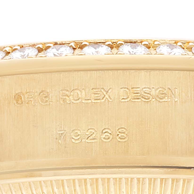 This close-up image of a Rolex President 79268 Women
s Yellow Gold Champagne Dial 79268 Women
s Yellow Gold Champagne Dial model shows the engraved serial number and part of the bejeweled bezel.
