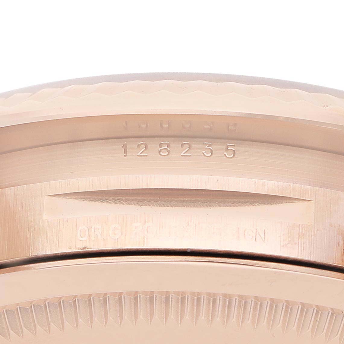 The image shows a close-up of the side case of the Rolex President 128235 Men's Rose Gold Grey Dial model, highlighting the serial number and bezel edge.