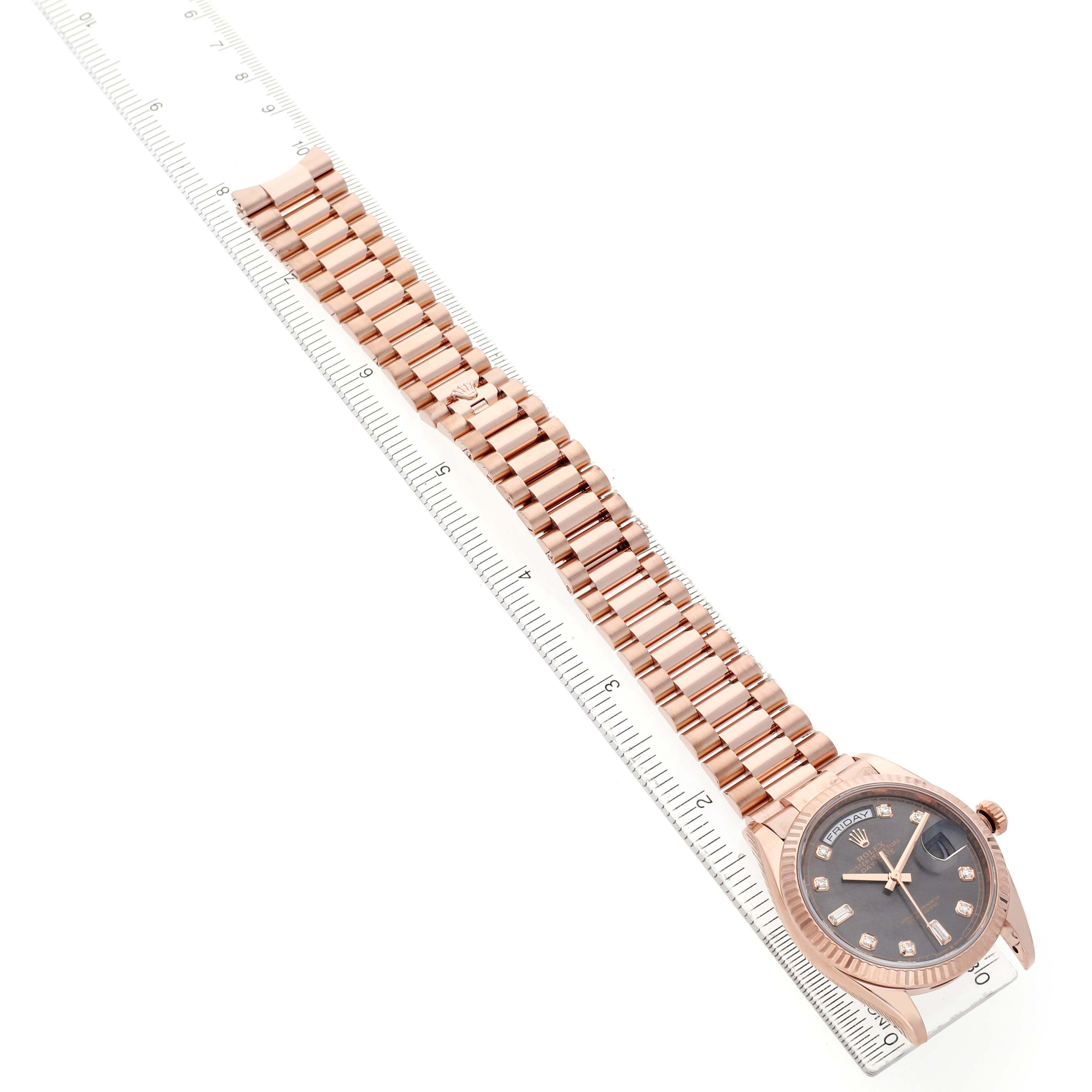 The image shows a Rolex President 128235 Men's Rose Gold Grey Dial model watch from a top-down angle, highlighting the bracelet and dial alongside a ruler.