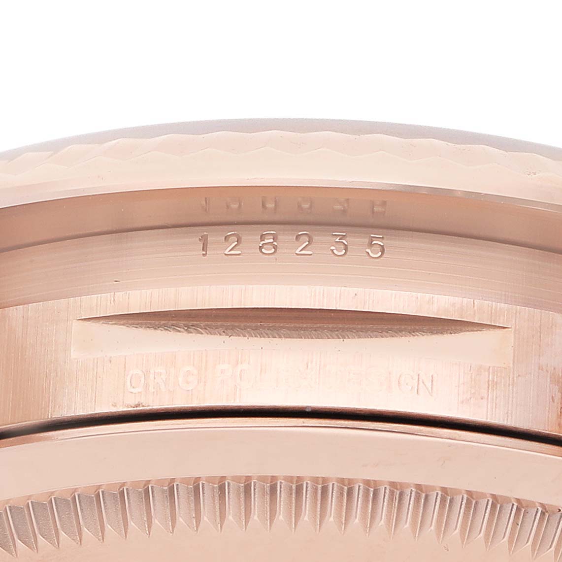 The image shows a close-up of the side and lug area of a Rolex President 128235 Men's Rose Gold Grey Dial watch, highlighting the serial number and detailed engravings.