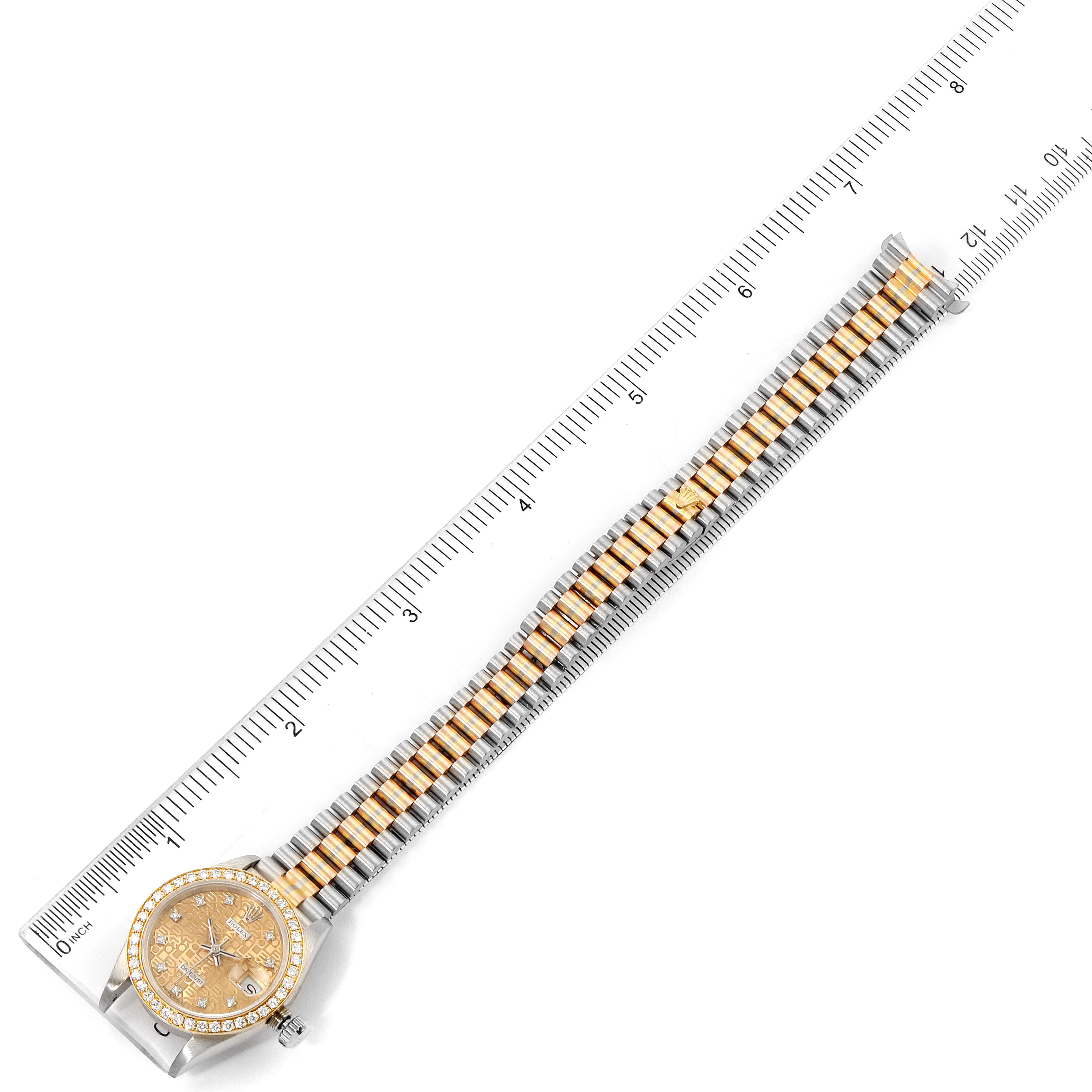 The image shows an overhead view of a Rolex President 69139 Women's White Gold Brown Dial 69139 Women's White Gold Brown Dial watch with its full band placed next to a ruler for scale.