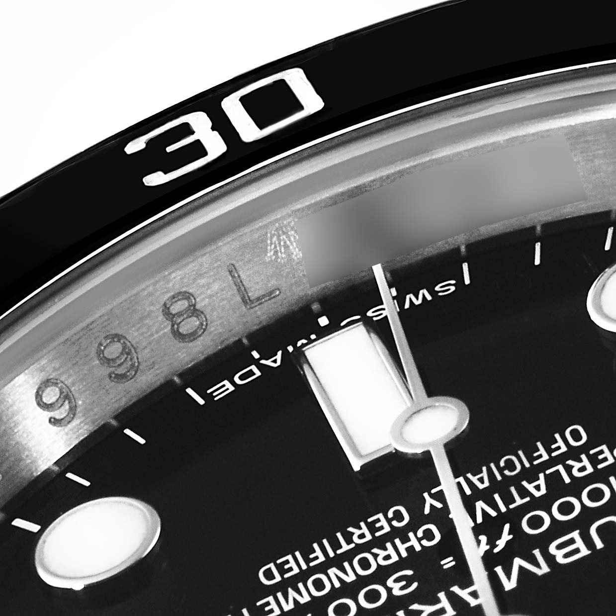 This close-up image of a Rolex Submariner 114060 Men
s Stainless Steel Black Dial 114060 Men
s Stainless Steel Black Dial watch shows part of the dial and bezel, specifically the 30-minute marker and some text on the dial.