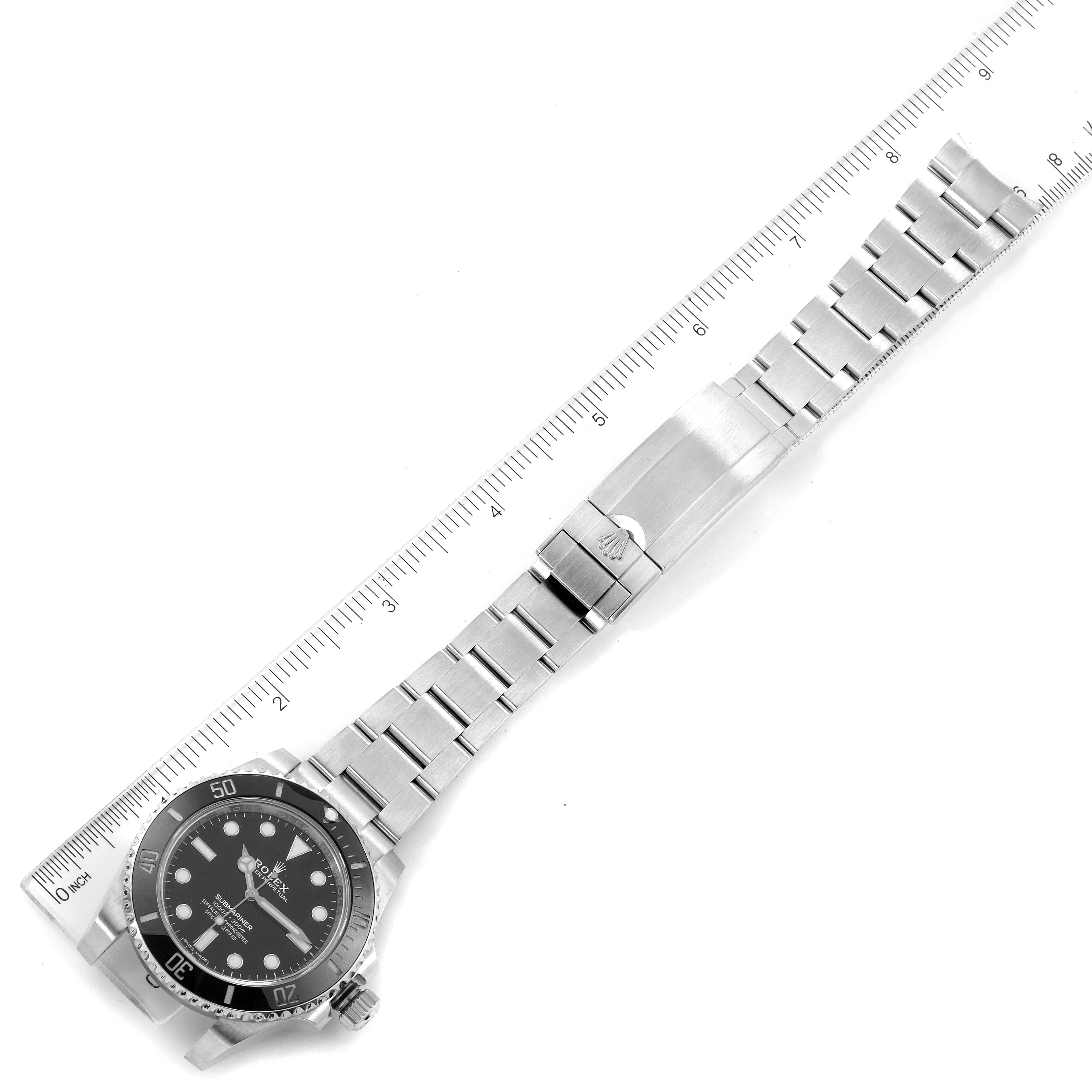 The image shows a top view of a Rolex Submariner 114060 Men
s Stainless Steel Black Dial 114060 Men
s Stainless Steel Black Dial watch, displaying the face, bezel, bracelet, and clasp, aligned with a ruler.