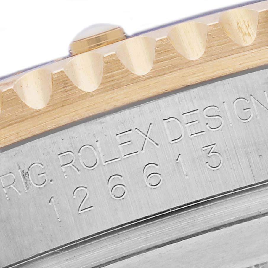 The image shows a close-up angle of the Rolex Submariner 126613LB Men's Steel and Gold (two tone) Blue Dial 126613LB Men's Steel and Gold (two tone) Blue Dial's engraved watch case and part of the gold bezel.