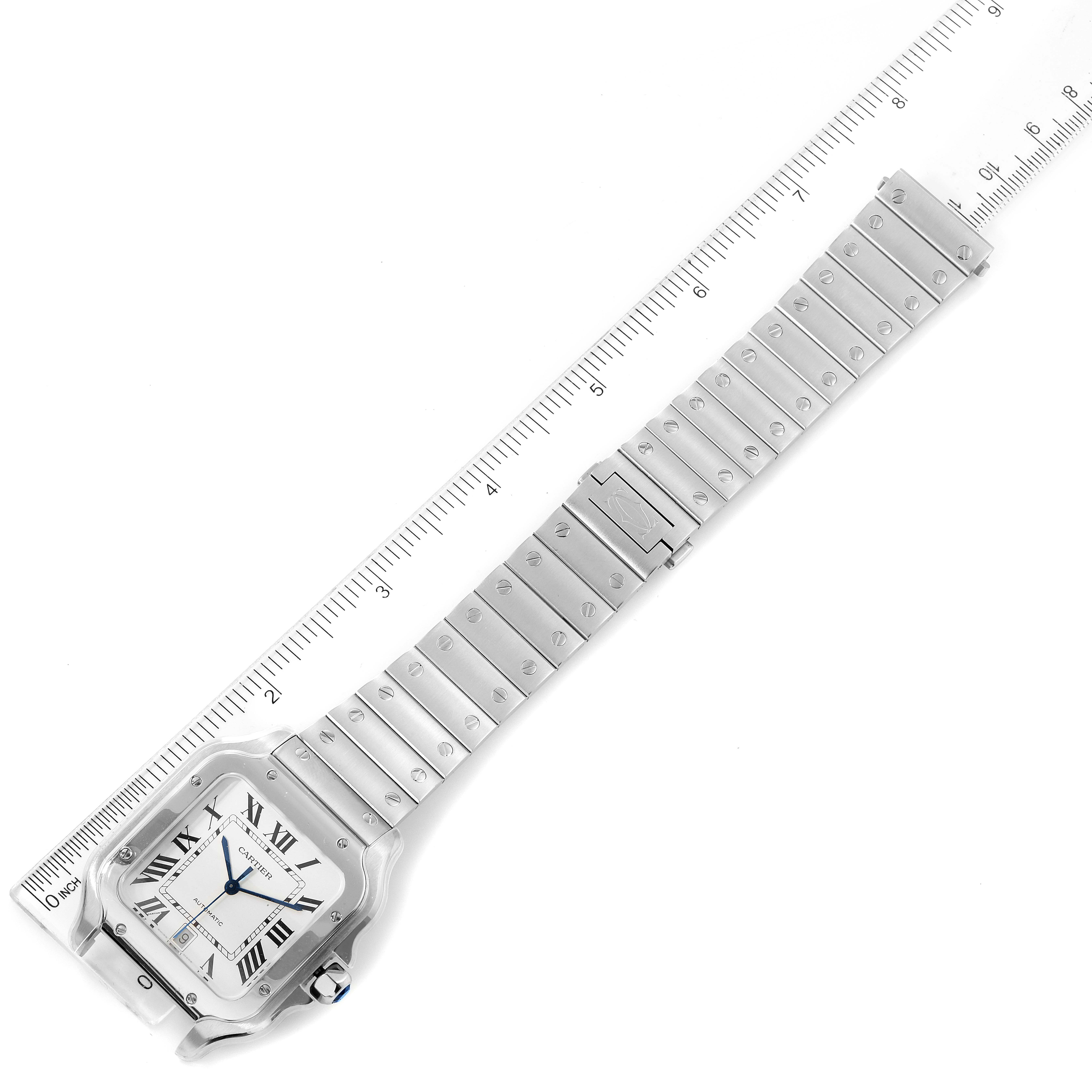 The image shows a top view of a Cartier Santos WSSA0018 Men's Stainless Steel Silver Dial WSSA0018 Men's Stainless Steel Silver Dial watch with its face and full metal bracelet, alongside a ruler.
