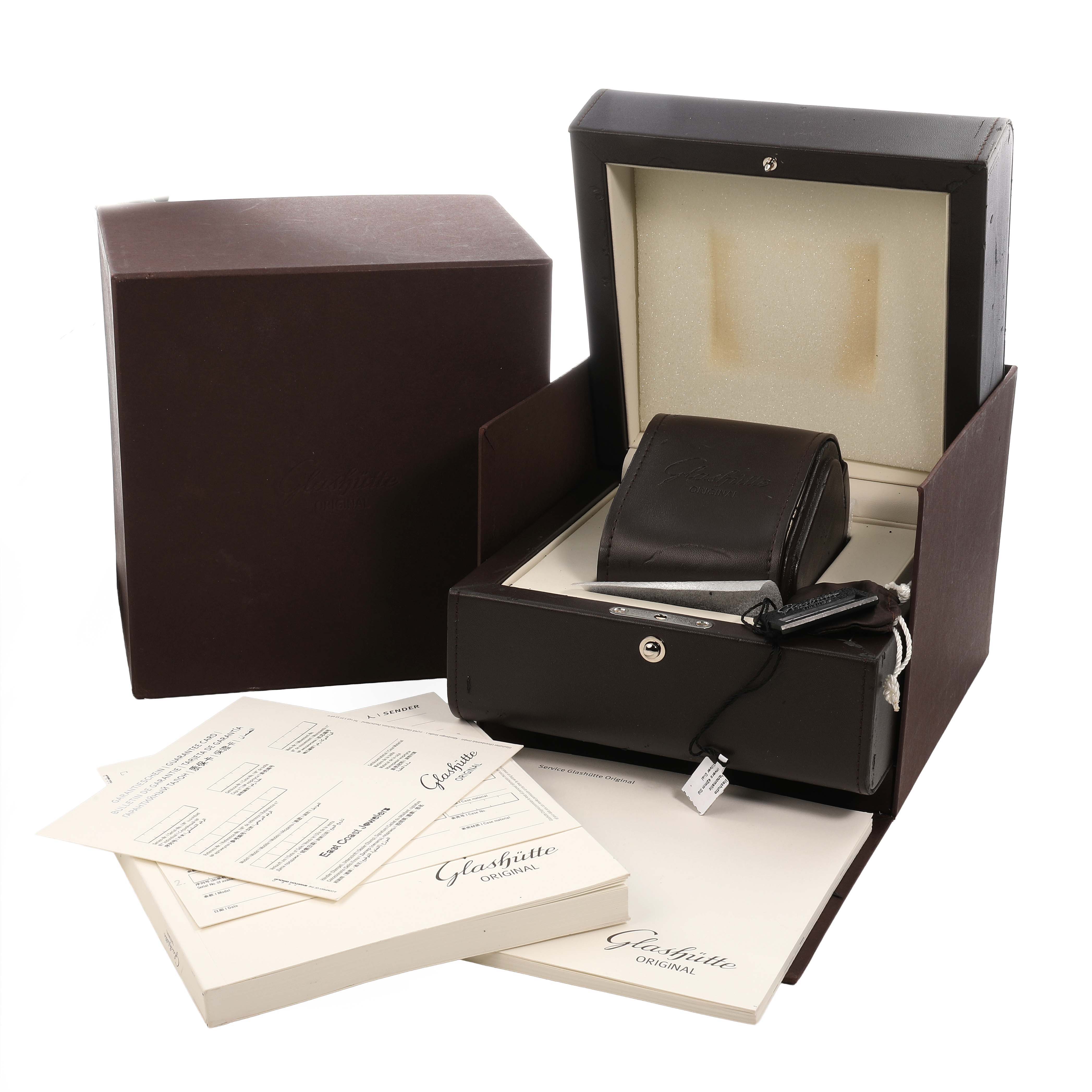 The image shows an open Glashütte Original box with accessories, documents, and a watch pouch.