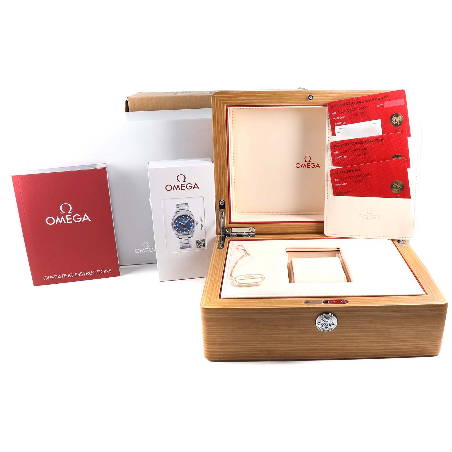 The image shows the packaging and accessories of an Omega Seamaster 220.10.40.20.03.001 Men
s Stainless Steel Blue Dial 220.10.40.20.03.001 Men
s Stainless Steel Blue Dial watch, including an open wooden box, manuals, and warranty cards.