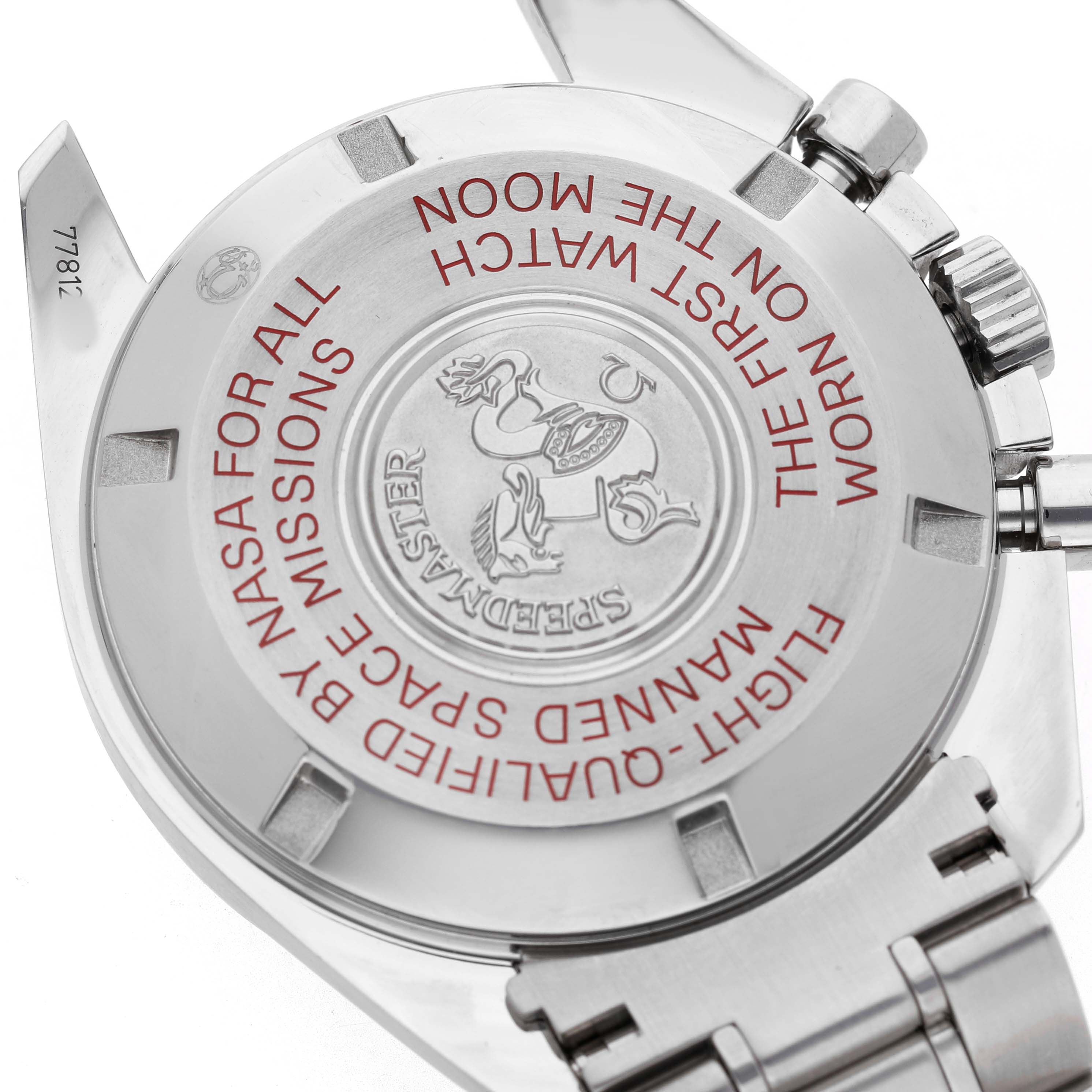 The image shows the back of an Omega Speedmaster 311.30.42.30.01.004 Men's Stainless Steel Black Dial watch, featuring its engravings and metal bracelet.