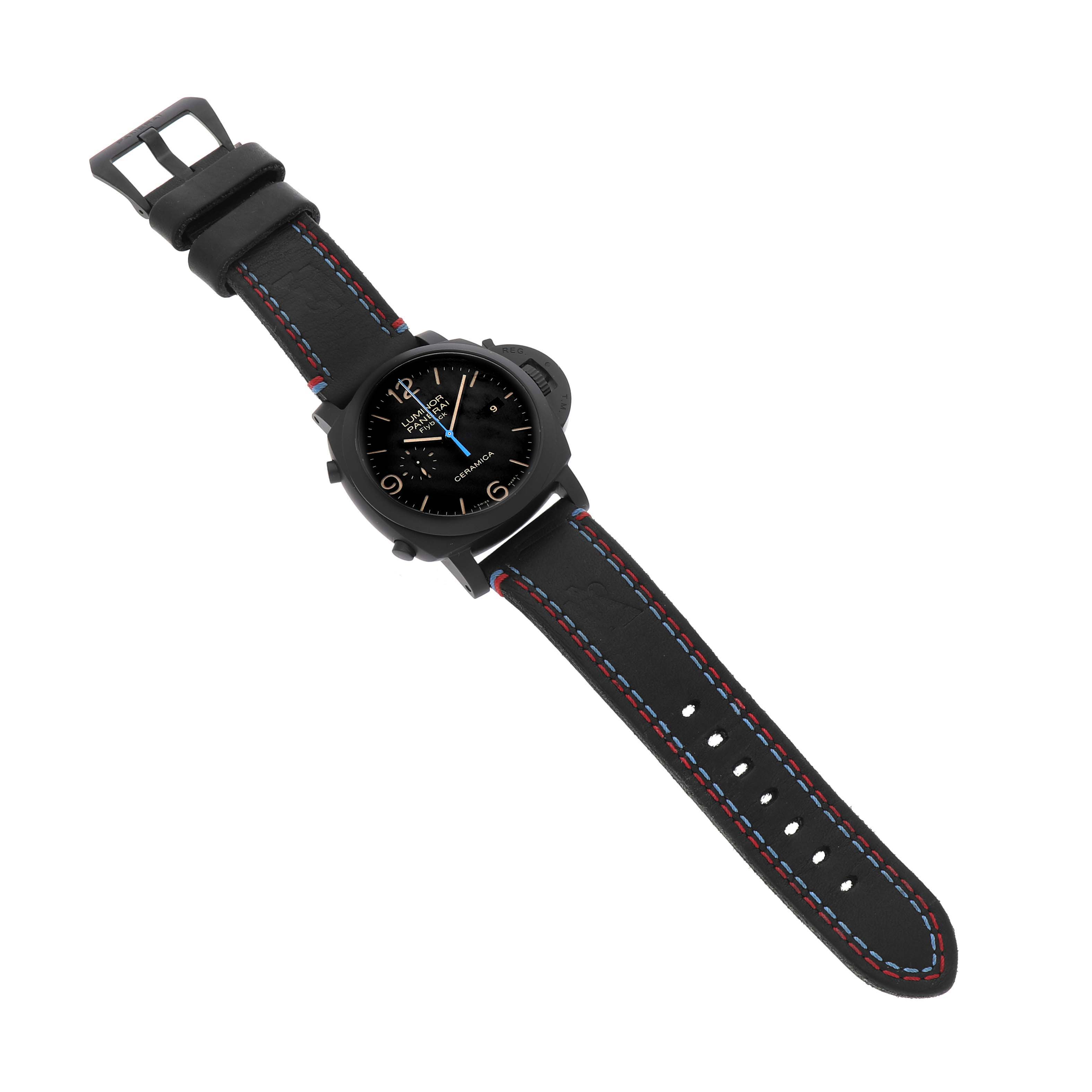 The Panerai Luminor PAM00580 Men's Ceramic Black Dial watch is shown from a top-down angle, highlighting the black dial, strap, and blue accent stitching.