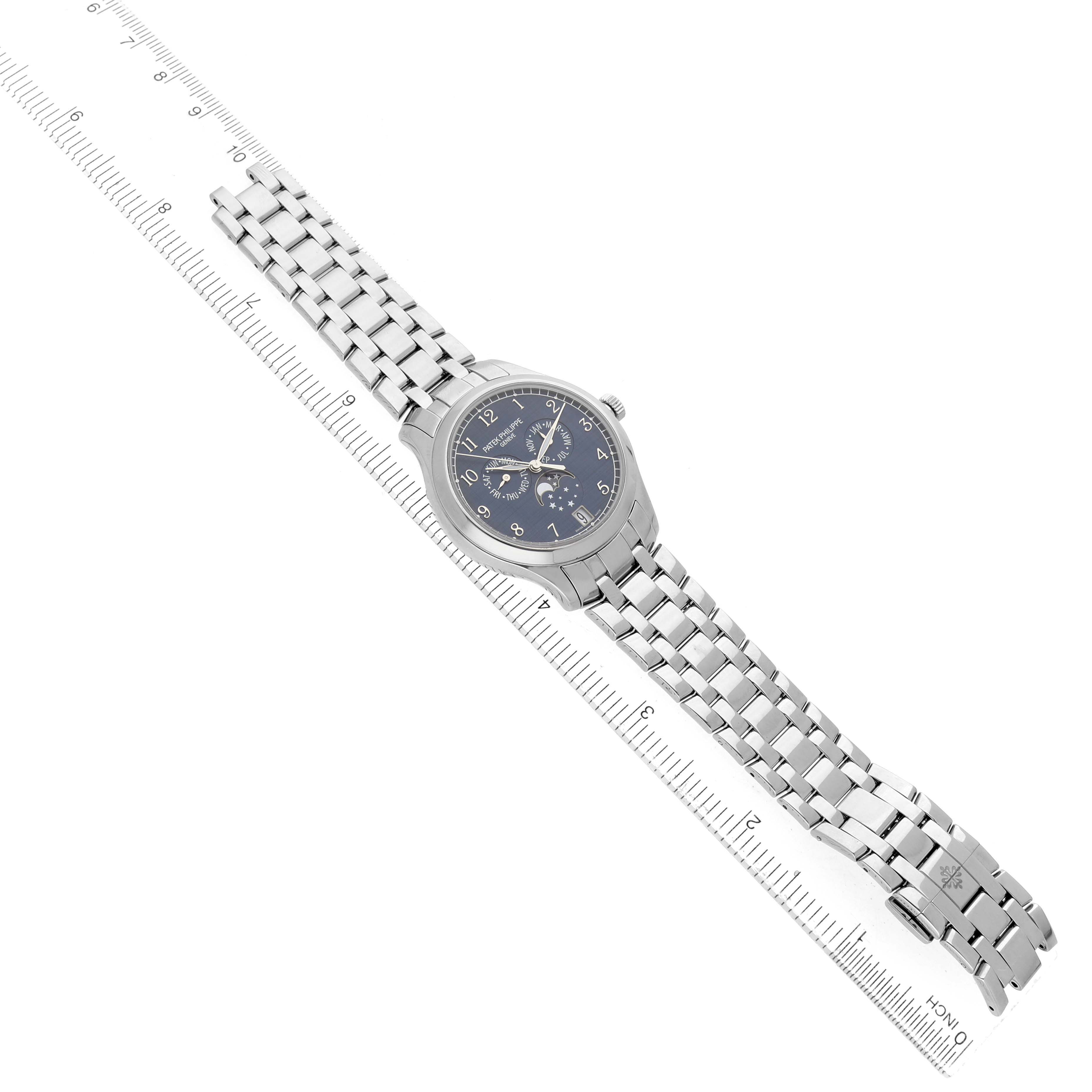 The Patek Philippe Complications 4947/1A-001 Men's Stainless Steel Blue Dial watch is shown from a top-down angle displaying the entire bracelet and face with a ruler for scale.