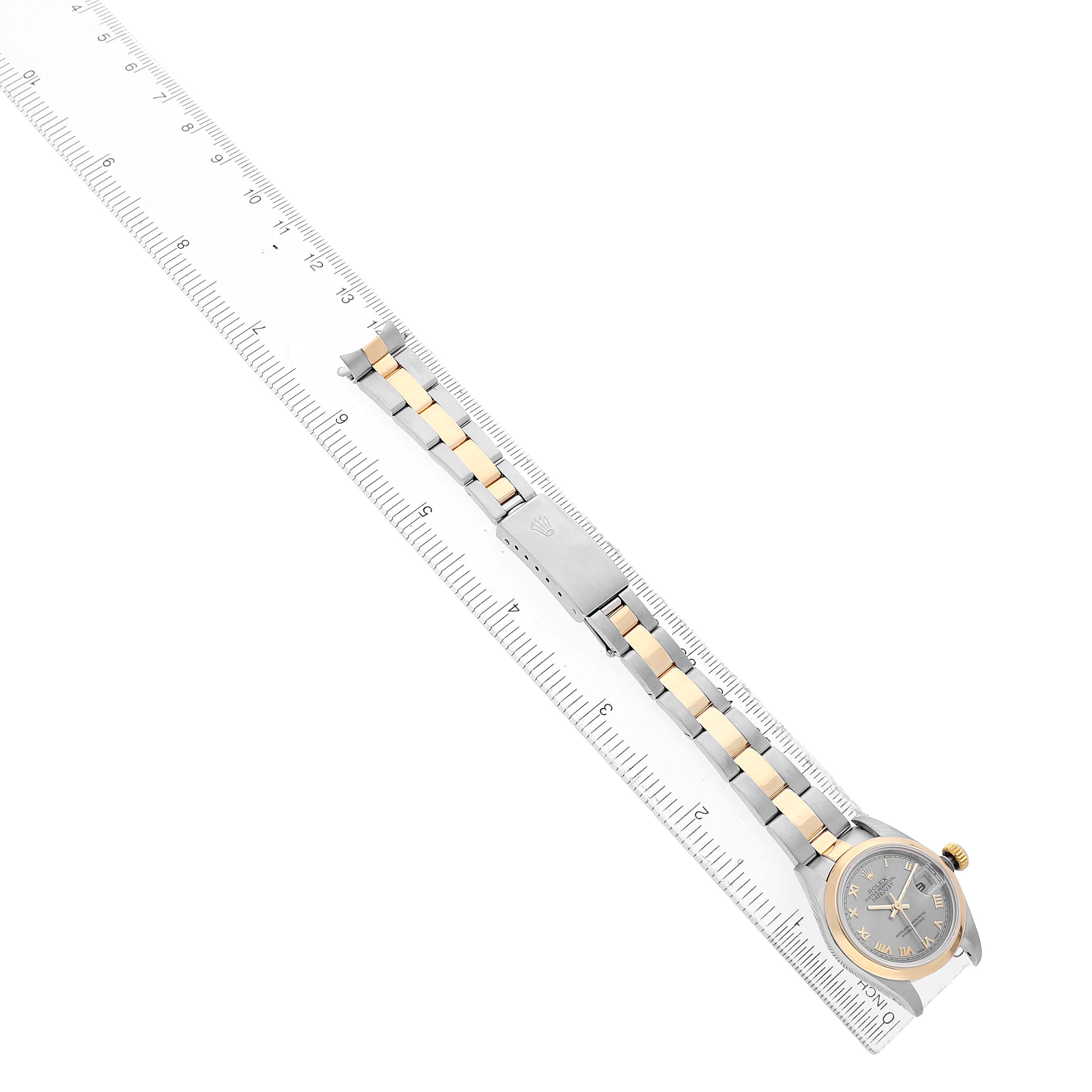The Rolex Datejust 79163 Women's Steel and Gold (two tone) Silver Dial watch is shown from a top-down angle, with its face, case, and Jubilee bracelet visible alongside a ruler for scale.