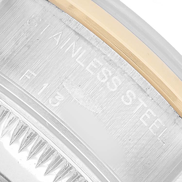 The image shows a close-up of the stainless steel side of a Rolex Datejust 79163 Women's Steel and Gold (two tone) Silver Dial, featuring part of the bezel and engraving.