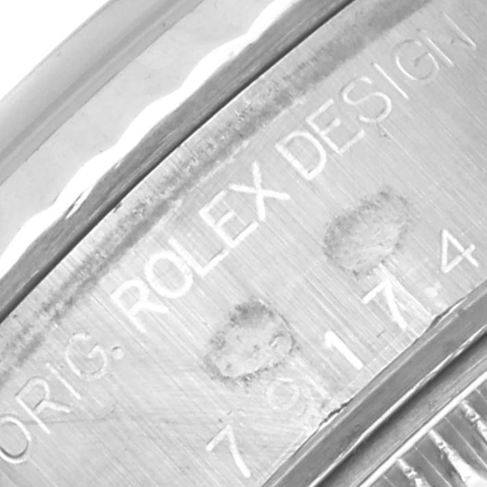 The image shows a close-up of the Rolex Datejust 79174 Women's Stainless Steel Mother of Pearl Dial 79174 Women's Stainless Steel Mother of Pearl Dial case side, highlighting engraved text details.