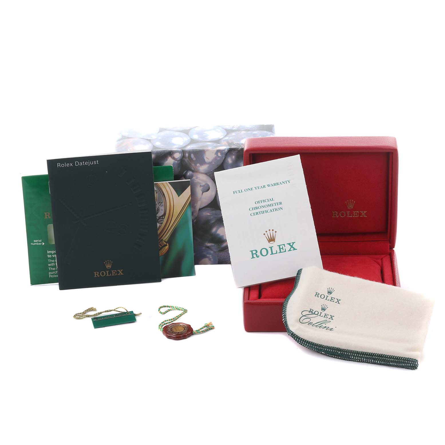 The image shows accessories for a Rolex Datejust 79174 Women's Stainless Steel Mother of Pearl Dial 79174 Women's Stainless Steel Mother of Pearl Dial, including a red box, booklets, tag, and cleaning cloth, viewed from the front.