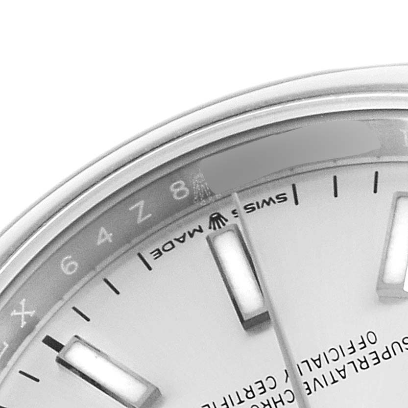 The image shows a close-up of the face and part of the bezel of a Rolex Datejust 126200 Men's Stainless Steel Silver Dial 126200 Men's Stainless Steel Silver Dial watch, particularly around the 8 o'clock mark.
