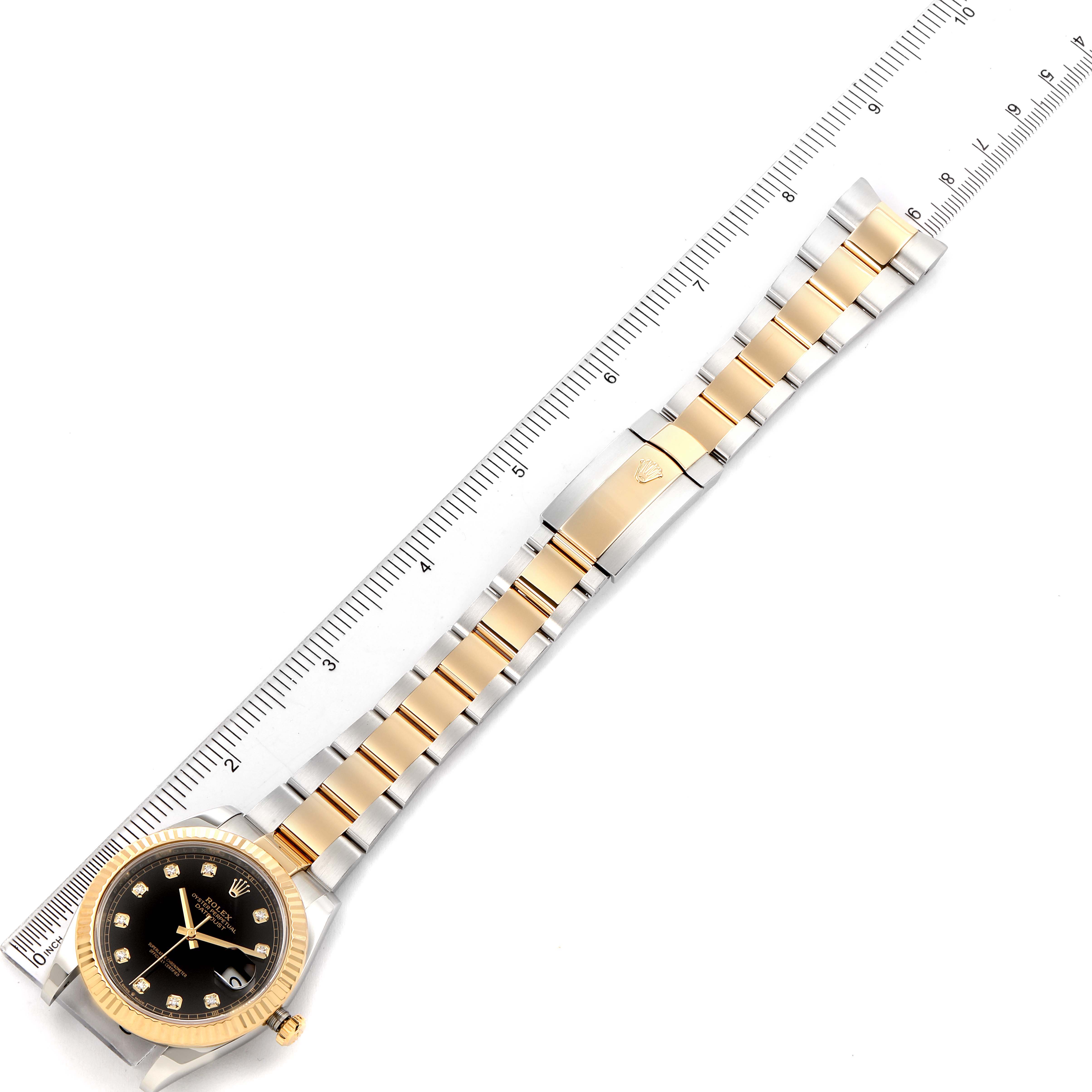 The image shows a Rolex Datejust 41 126333 Men's Steel and Gold (two tone) Black Dial 126333 Men's Steel and Gold (two tone) Black Dial watch lying flat, fully displaying the dial, bracelet, and clasp next to a ruler for scale.